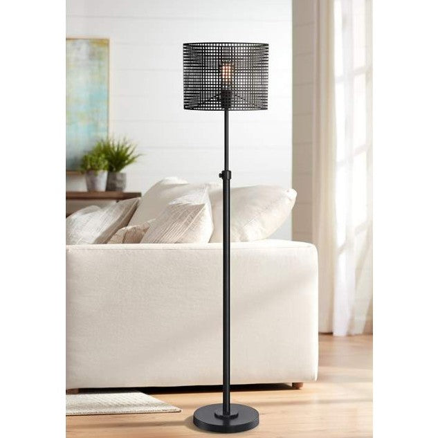 Black floor lamp with a grid-pattern metal shade next to a cream sofa in a bright living room.