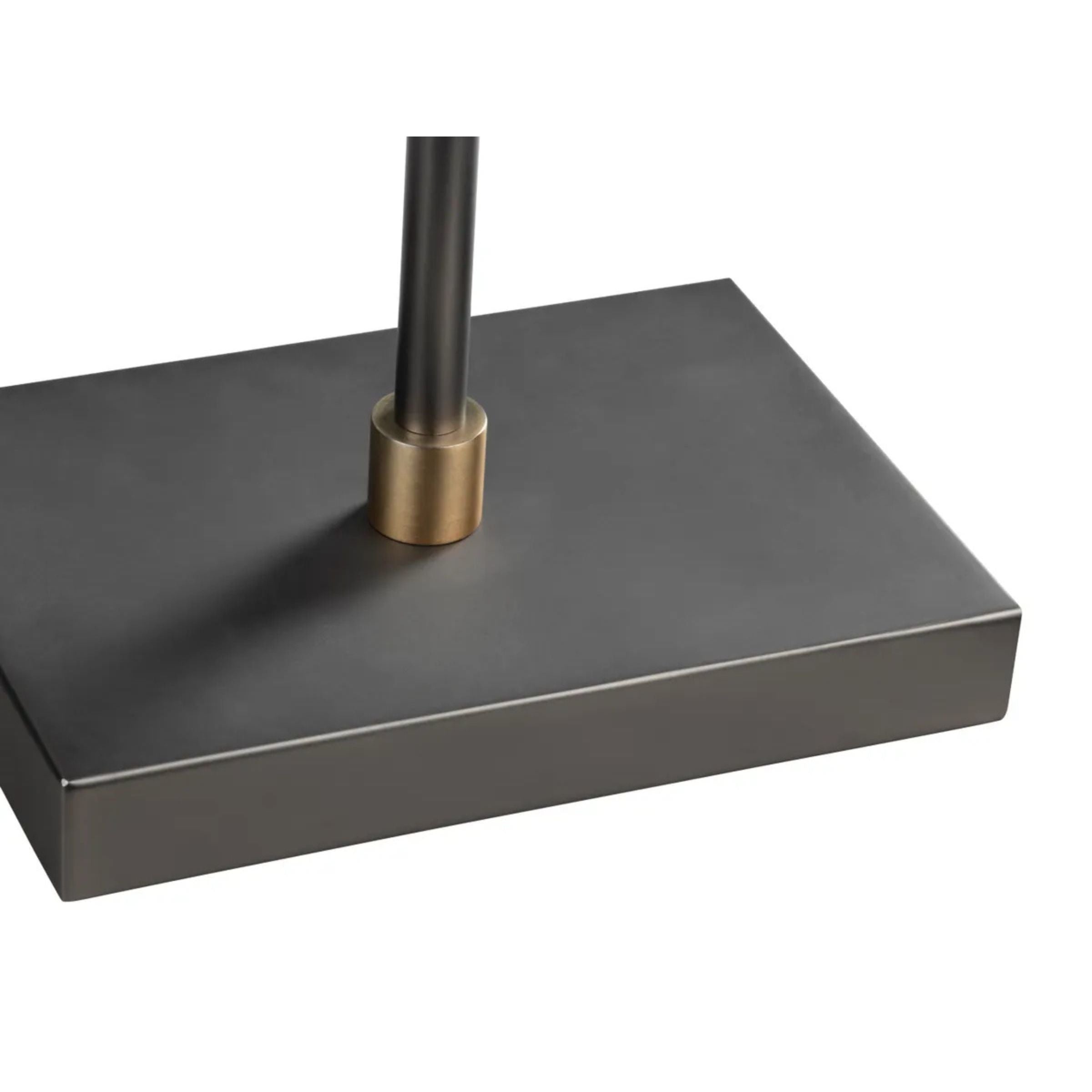 Close-up of a rectangular, dark metal lamp base with a brass accent.