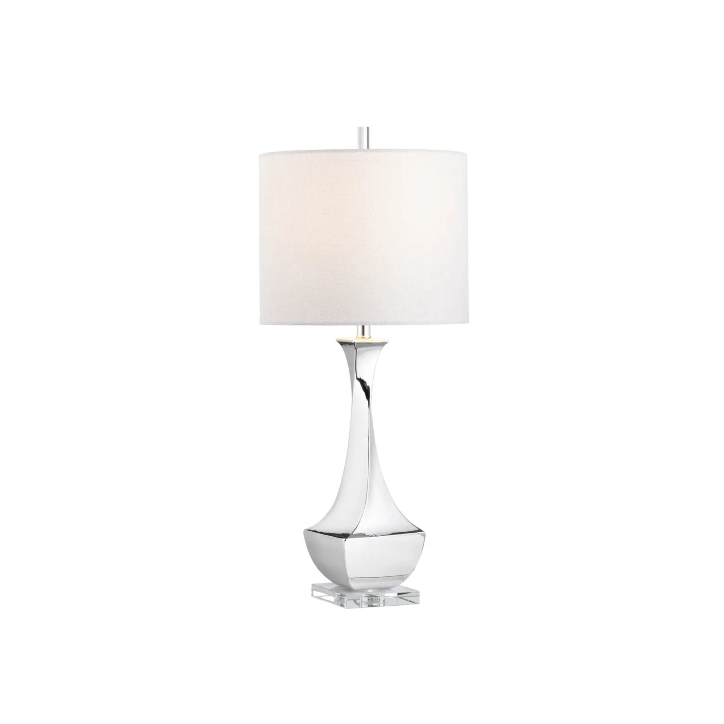 Modern table lamp with a silver base and white drum shade.