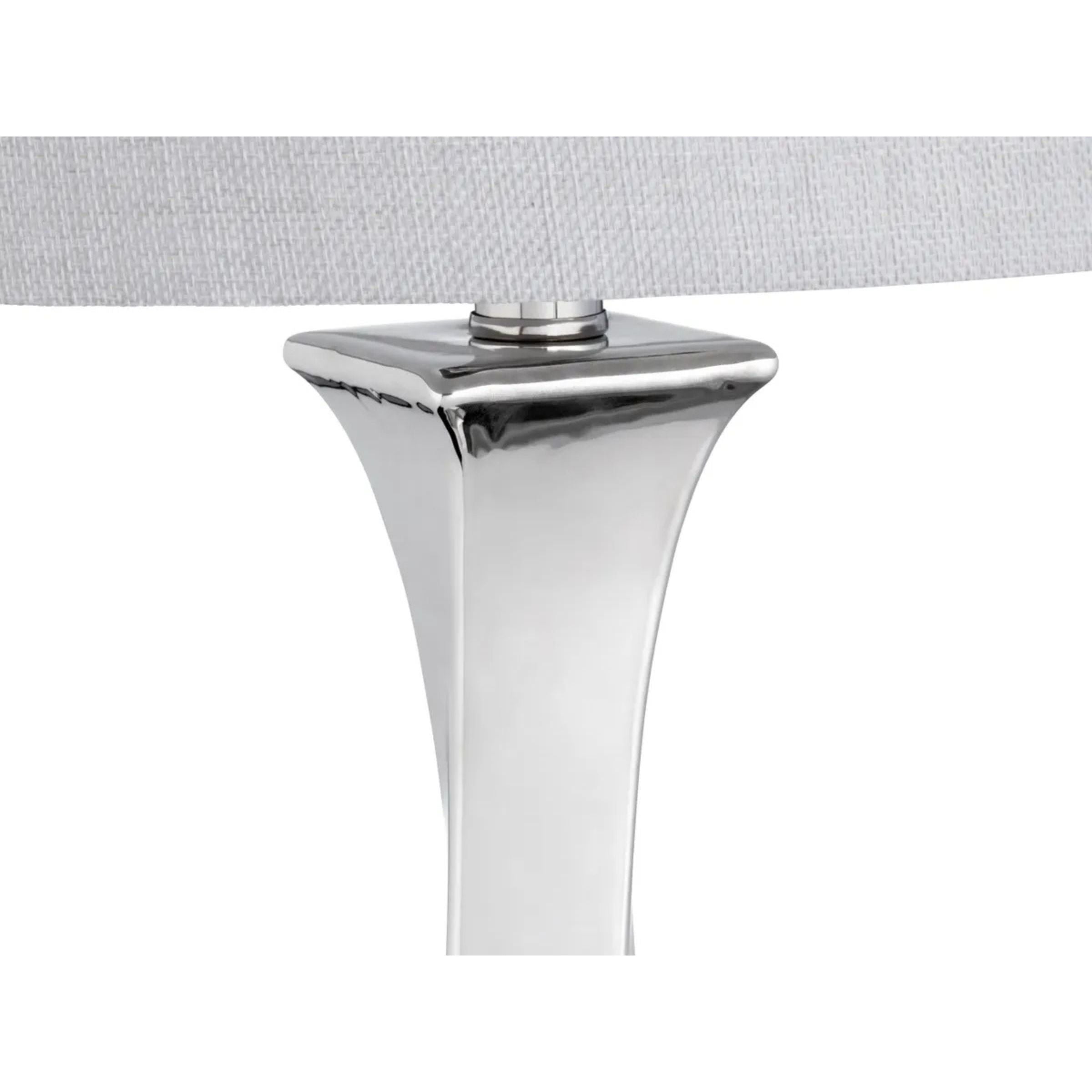 Close-up of a modern chrome lamp base with a light fabric shade.