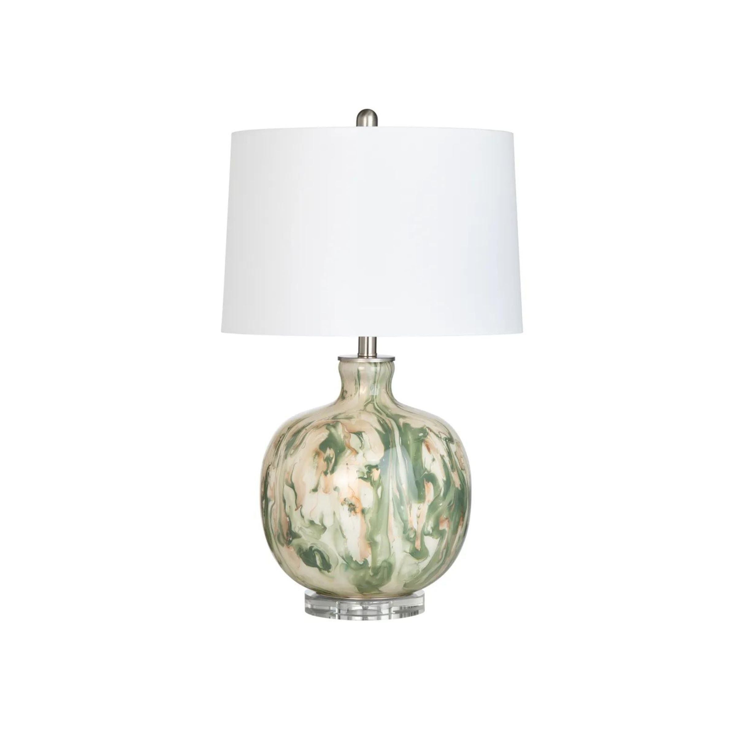 Table lamp with a swirled green and cream ceramic base and white fabric shade.