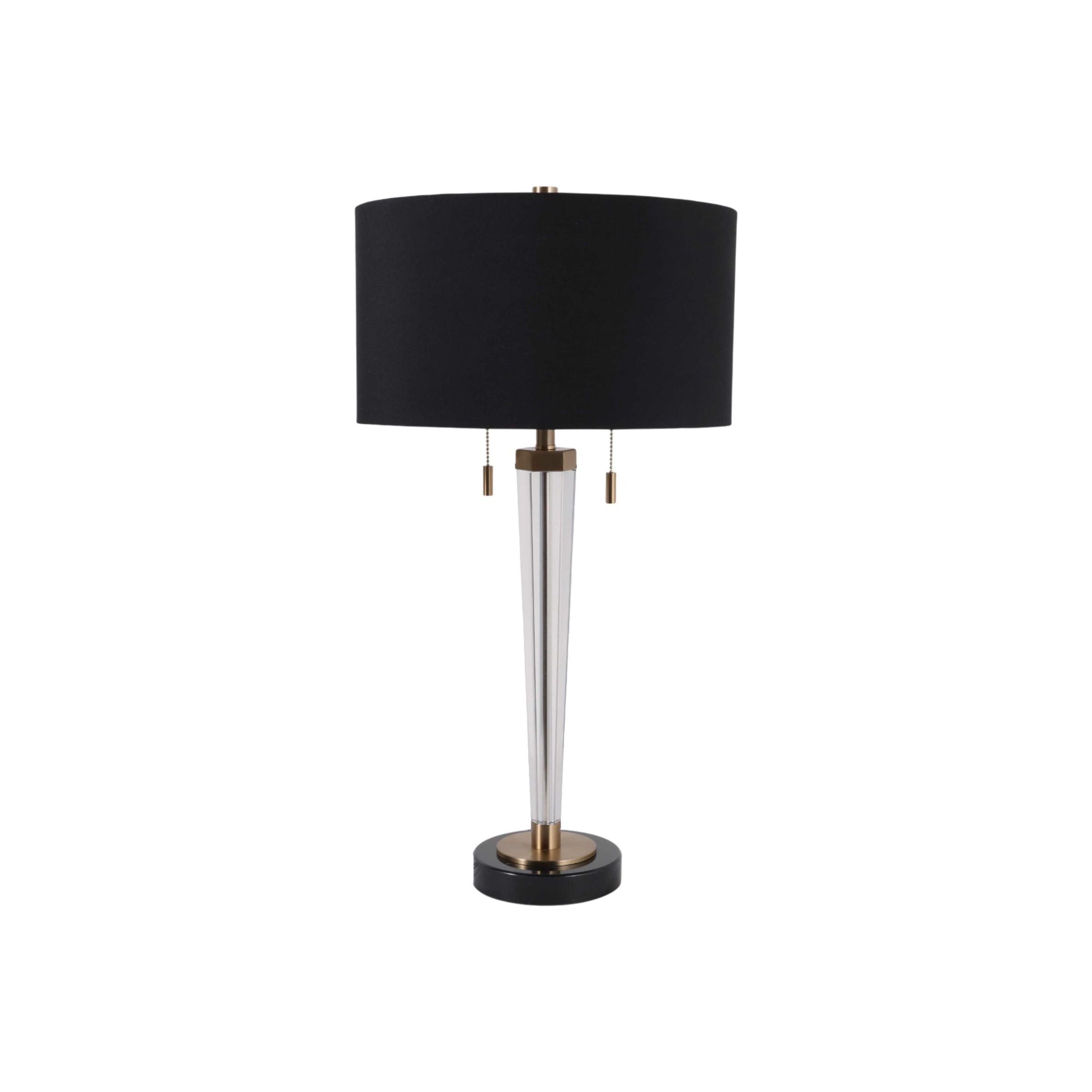 Modern table lamp with a black shade, clear tapered base, and brass accents.