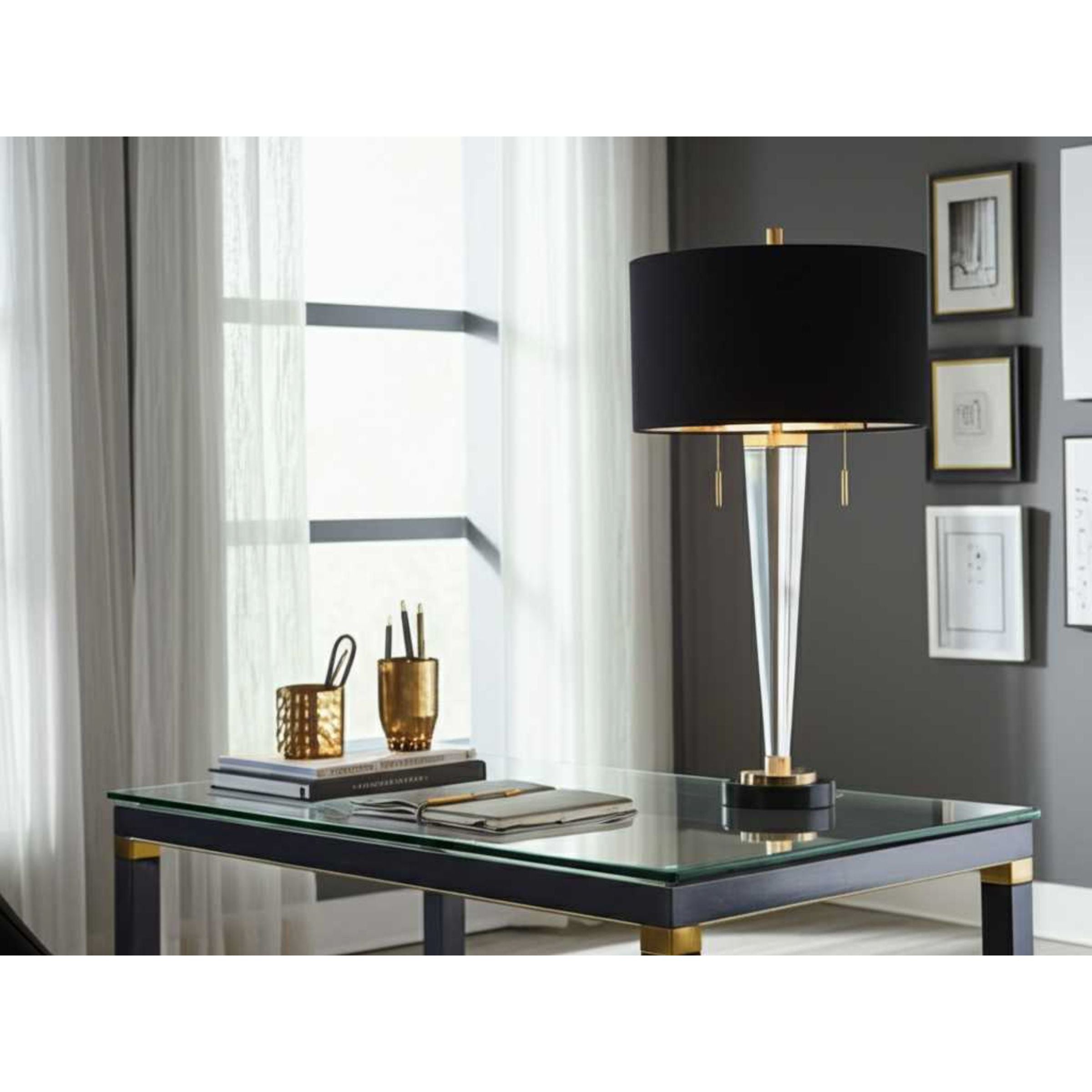 Modern glass desk lamp with black shade on a glass-top desk in a stylish office.