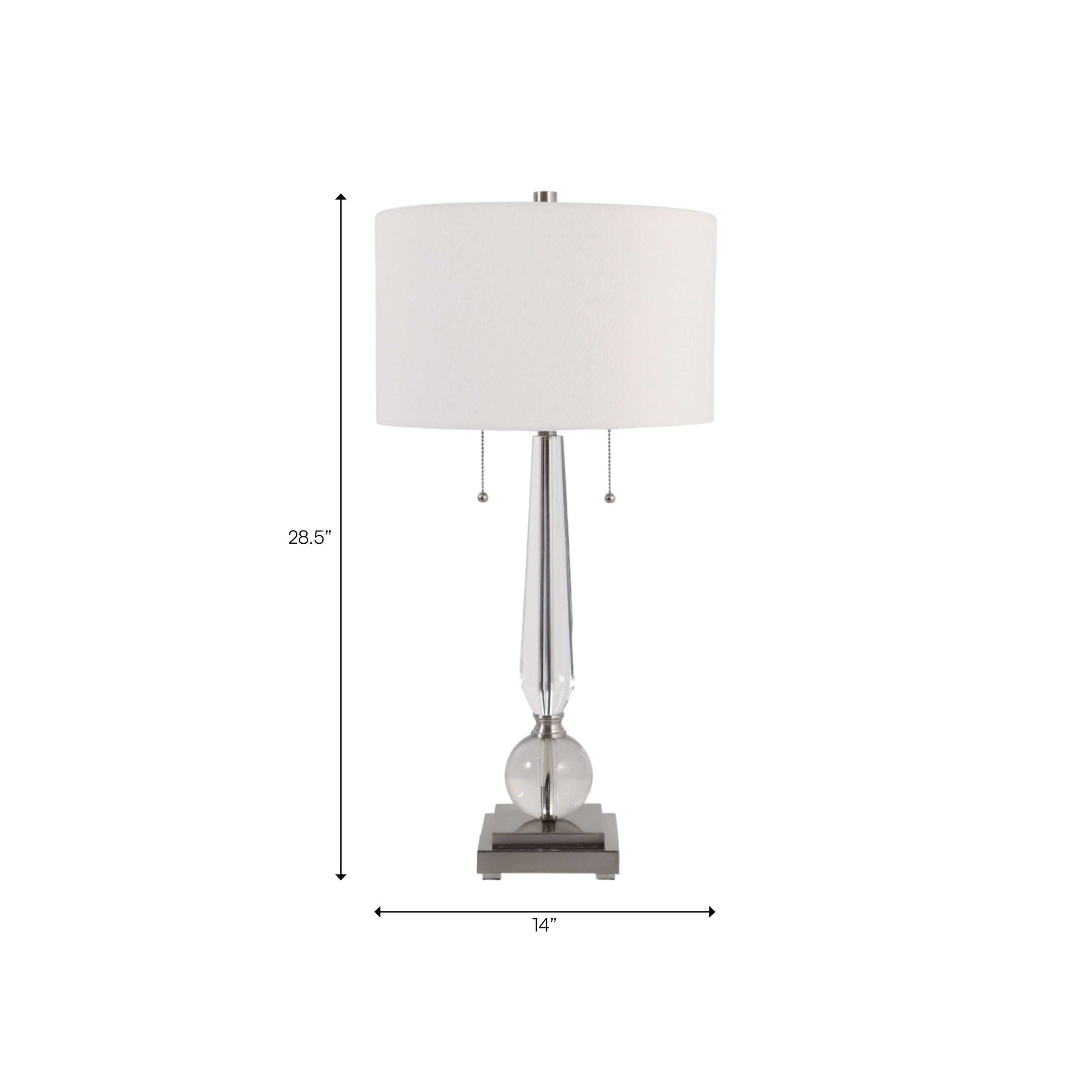 Modern table lamp with a white shade, silver base, and measurements of 28.5 inches tall and 14 inches wide.