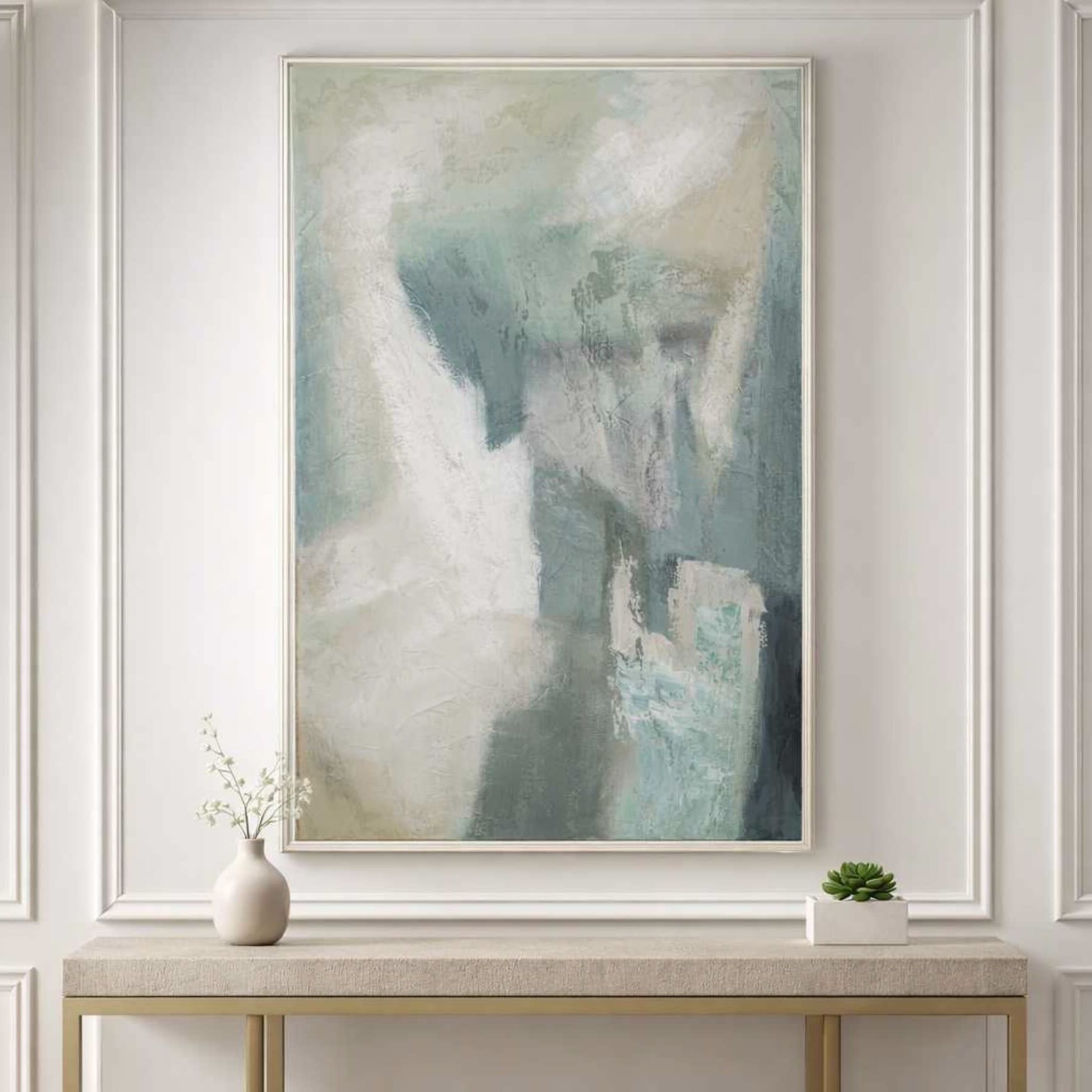 Abstract pastel art in blue and white tones hangs above a console table with simple decor.
