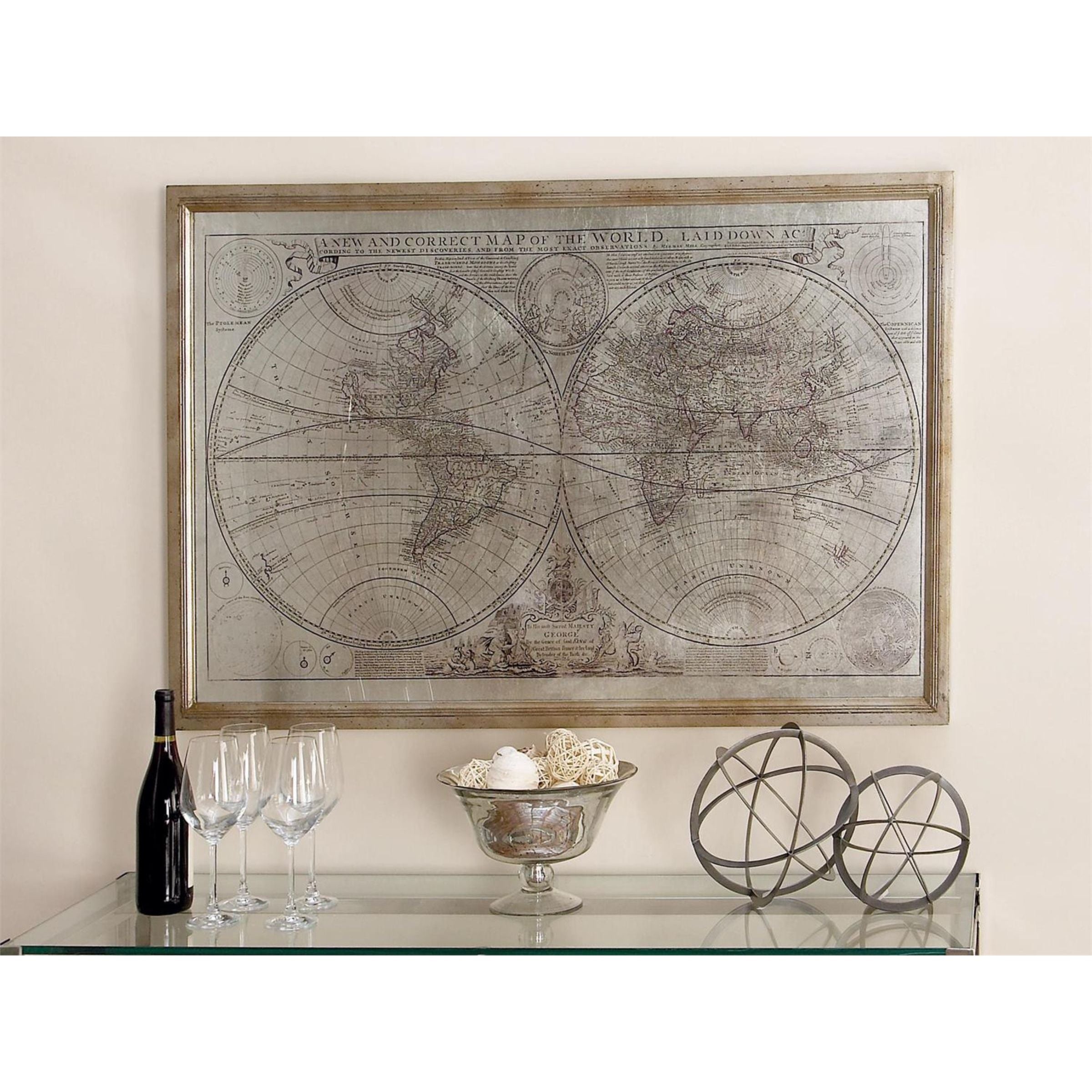 Framed vintage world map above a glass shelf with wine, glasses, and decorative objects.