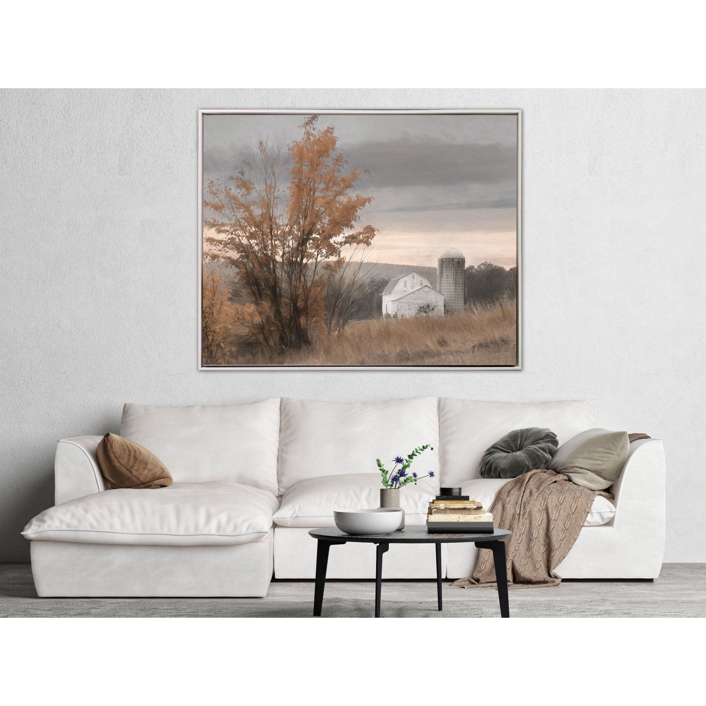 Framed landscape painting above a white sofa in a modern living room.