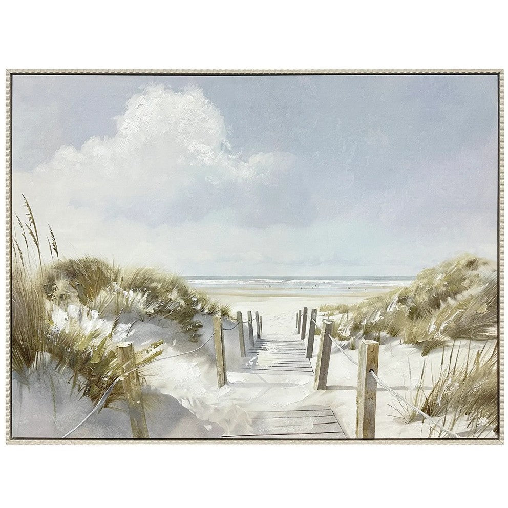 A sandy path with a wooden fence leads through dunes to a calm, open beach under a cloudy sky.