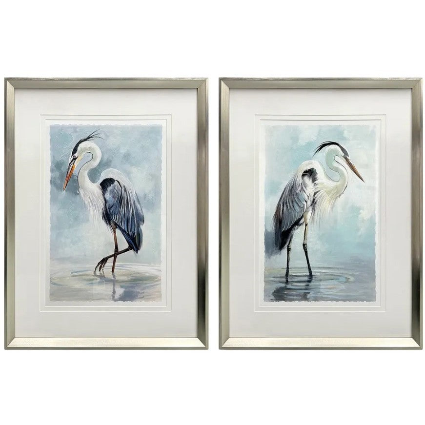 Framed watercolor paintings of herons standing in water against a soft blue background.