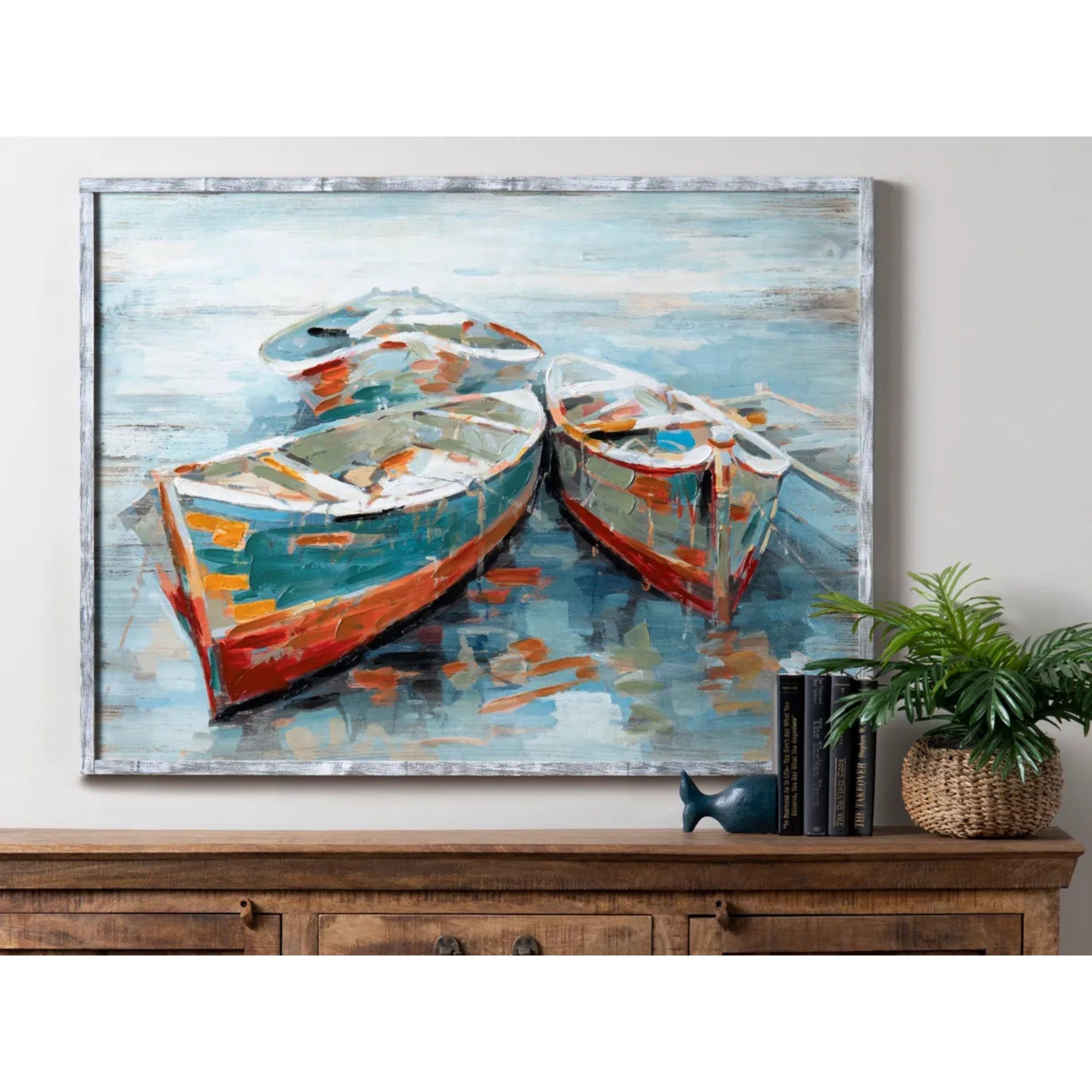 Painting of three colorful rowboats on water in a rustic wood frame.