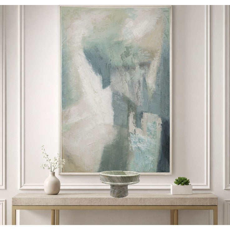 Abstract blue and white painting above console table with vase and plant.