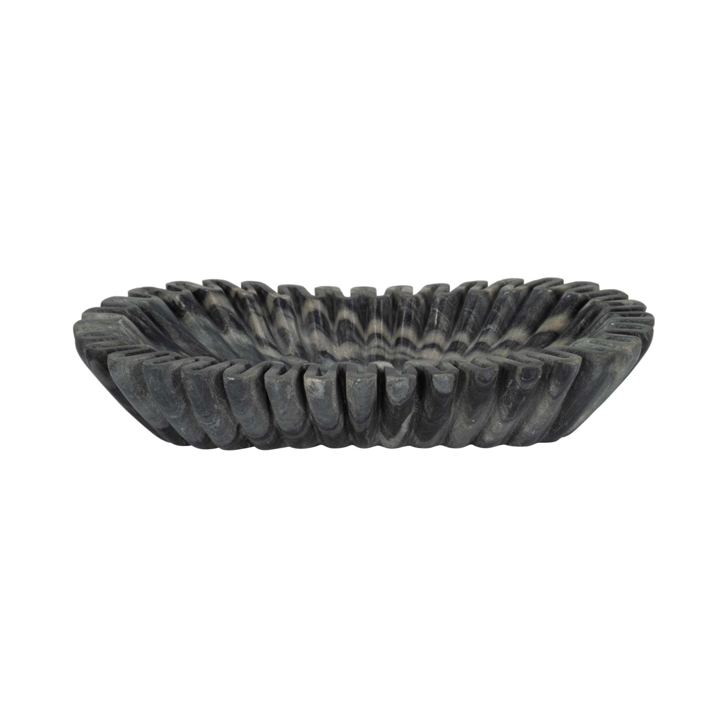 Shallow, oval dark stone bowl with carved, ribbed sides.