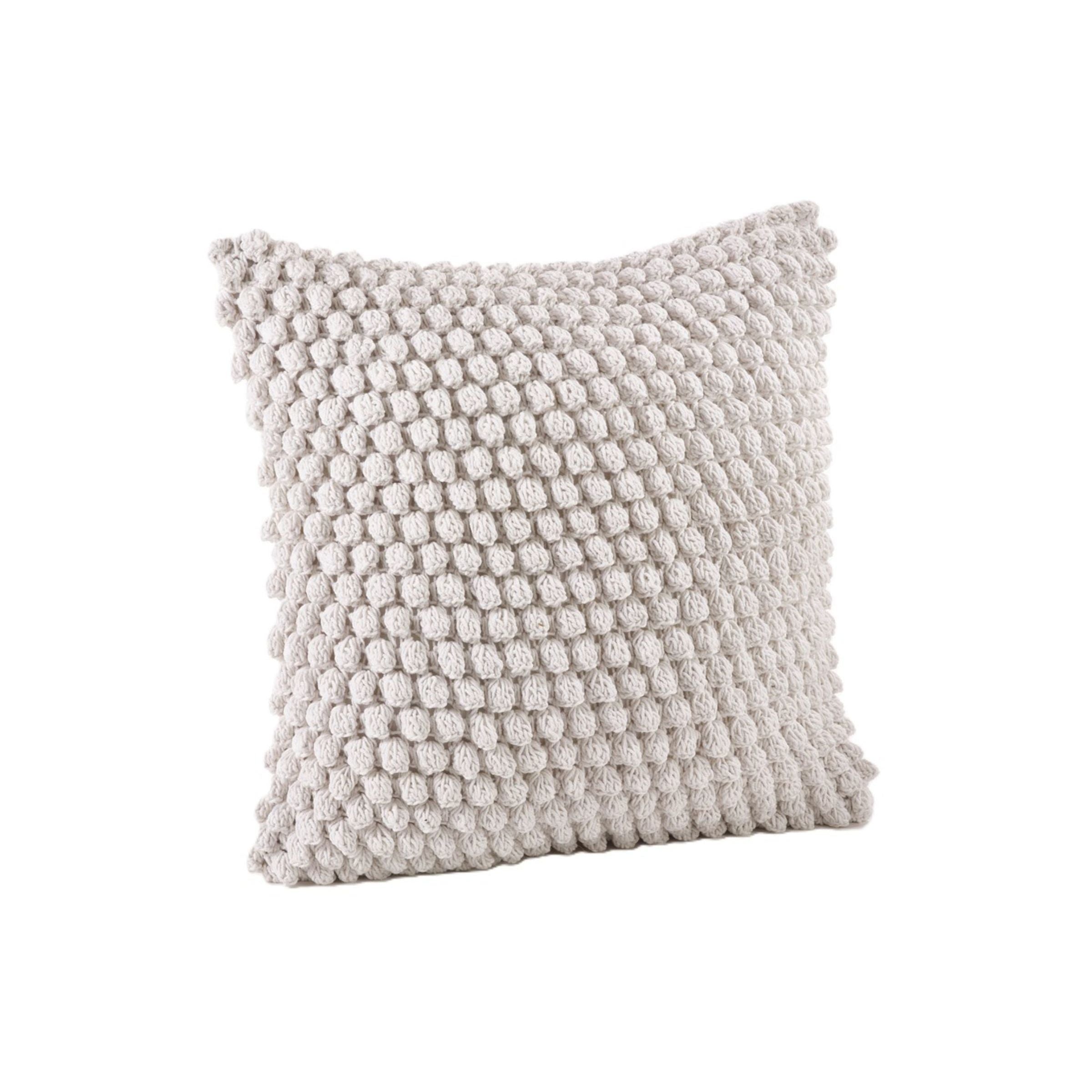 Square pillow with chunky textured knit in light beige.