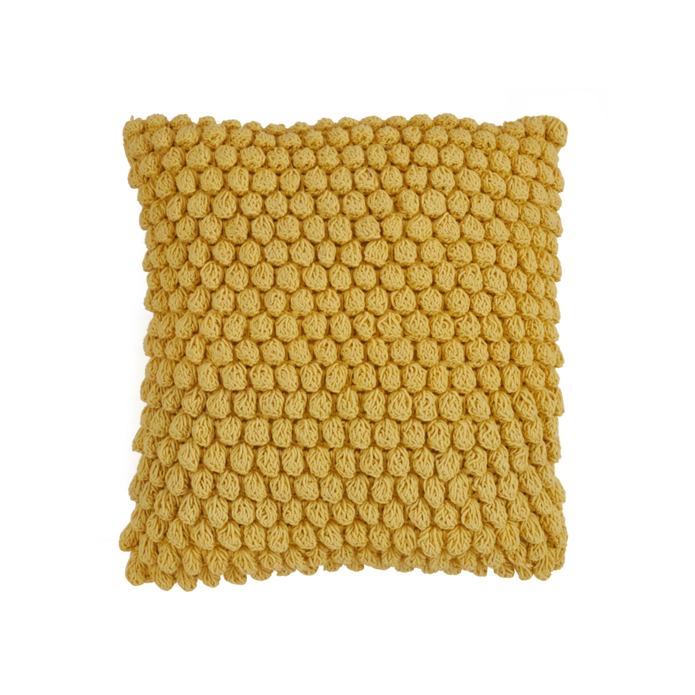 Square yellow pillow with textured knit bubble design.