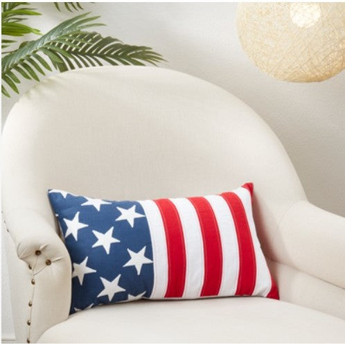 Decorative pillow with American flag stars and stripes on a white armchair.