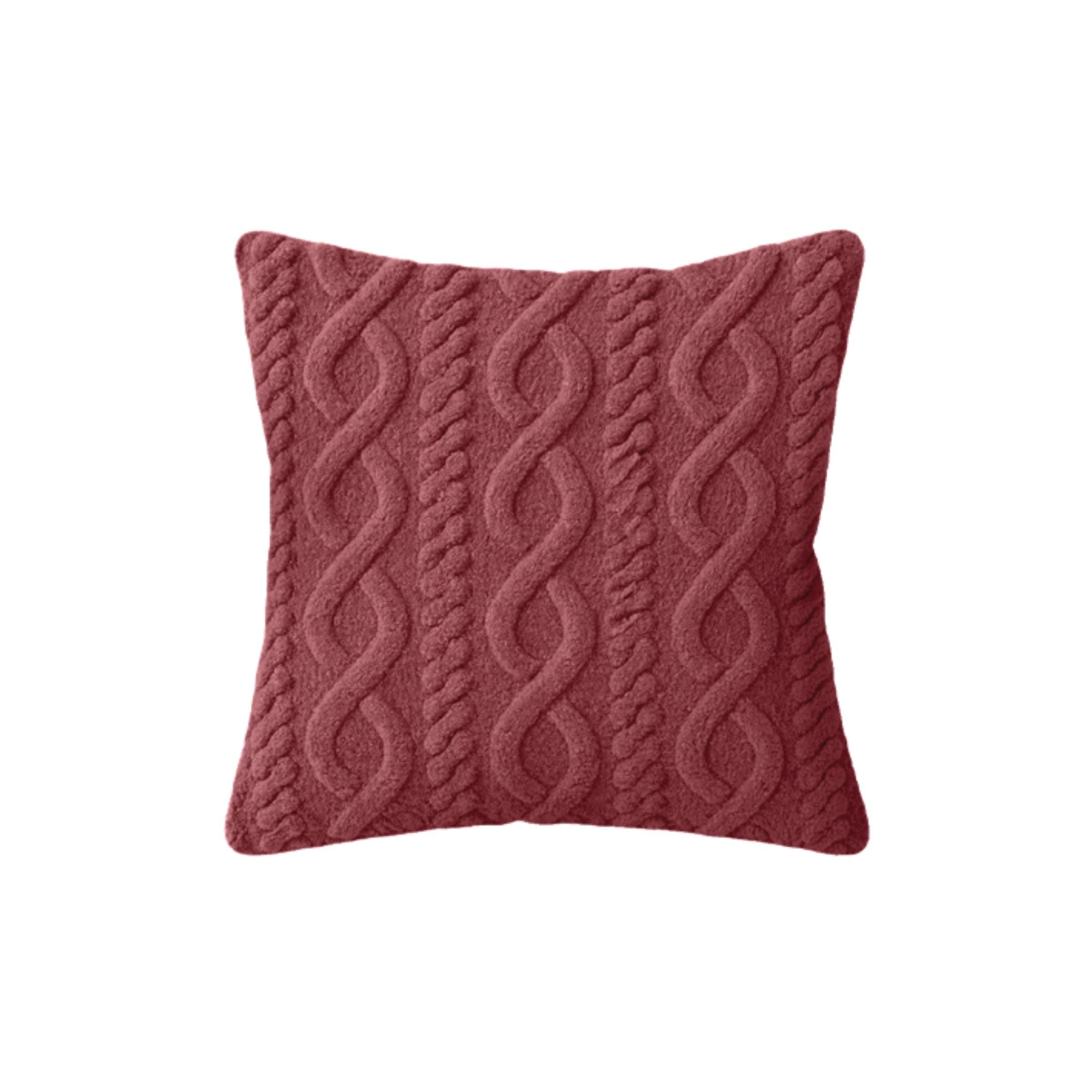 Red square pillow with a textured cable knit pattern.