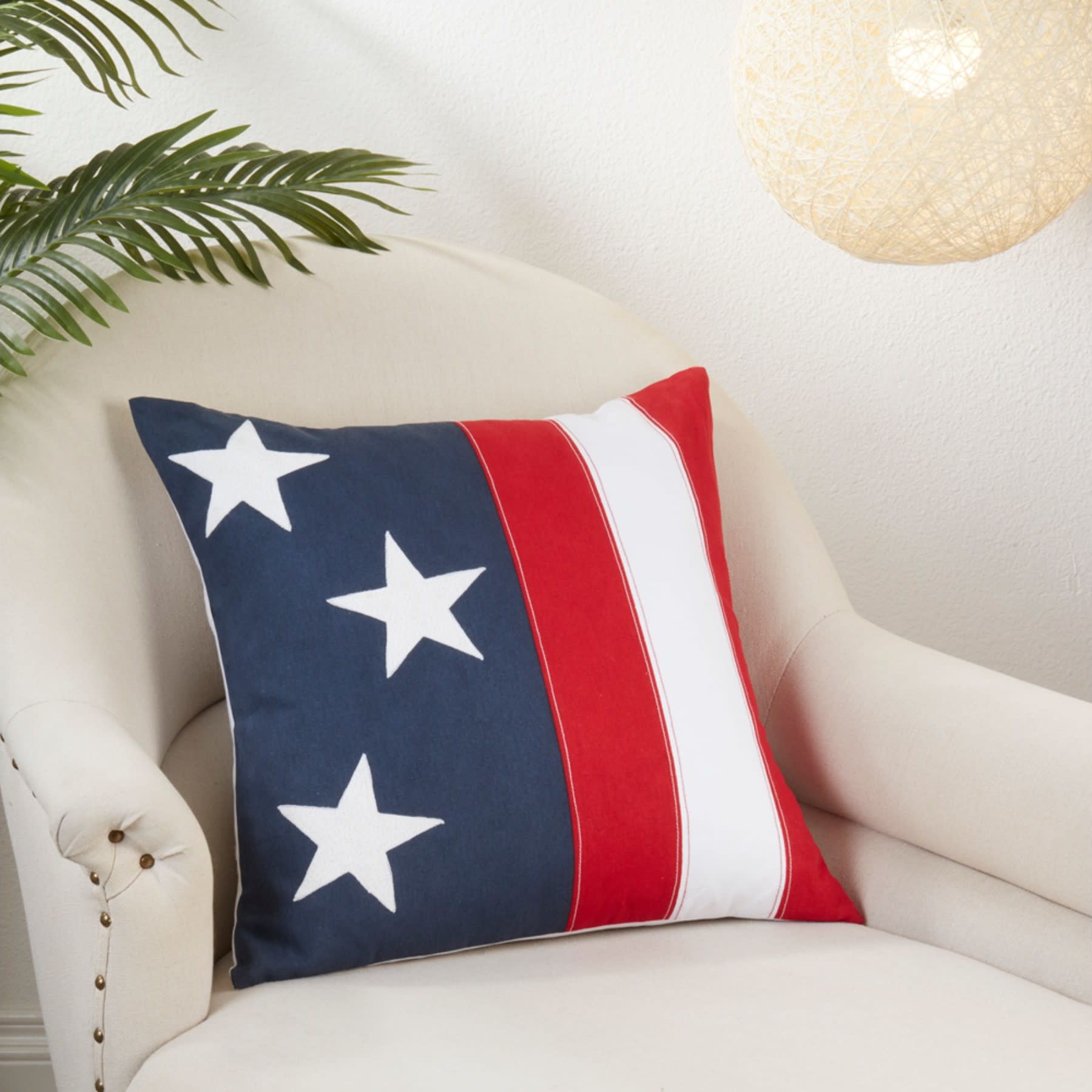 Patriotic pillow with stars and stripes on a cream armchair.