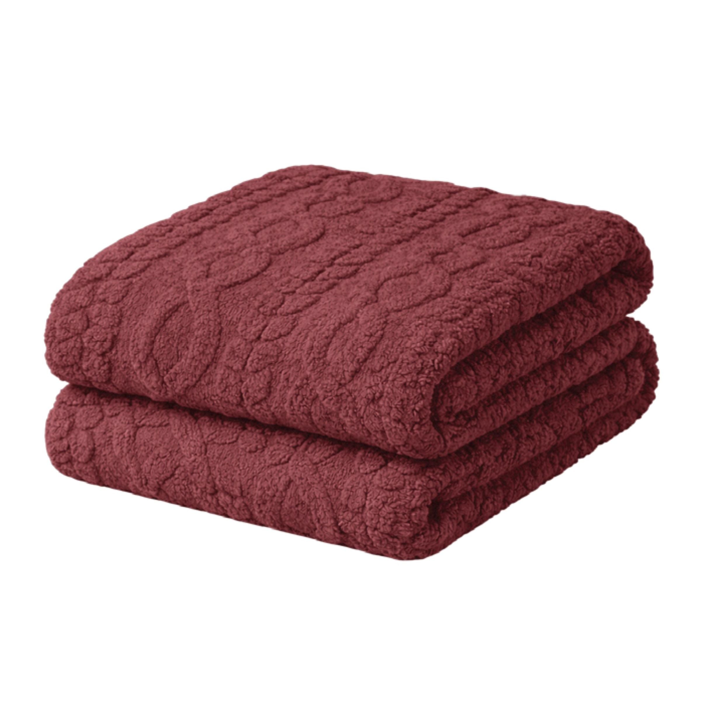 Folded maroon textured towel, suitable for bathroom or spa use.
