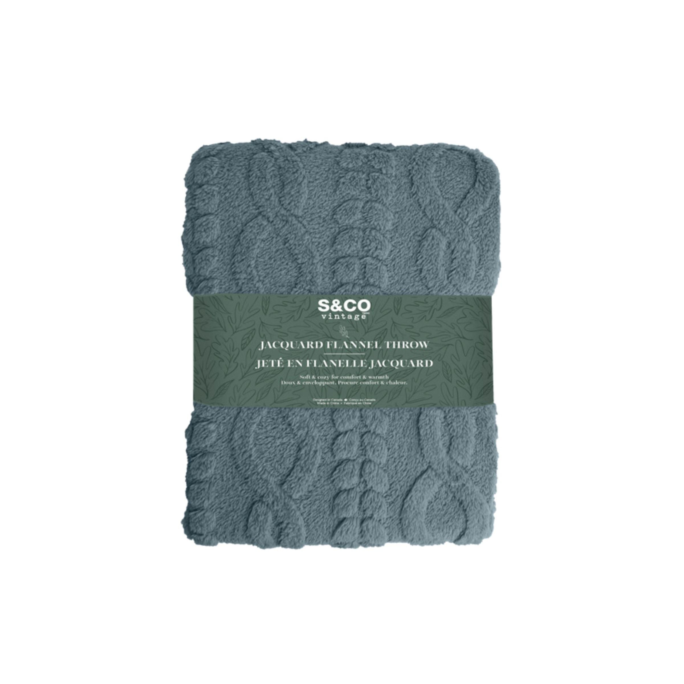 Blue jacquard flannel throw, folded with decorative label.