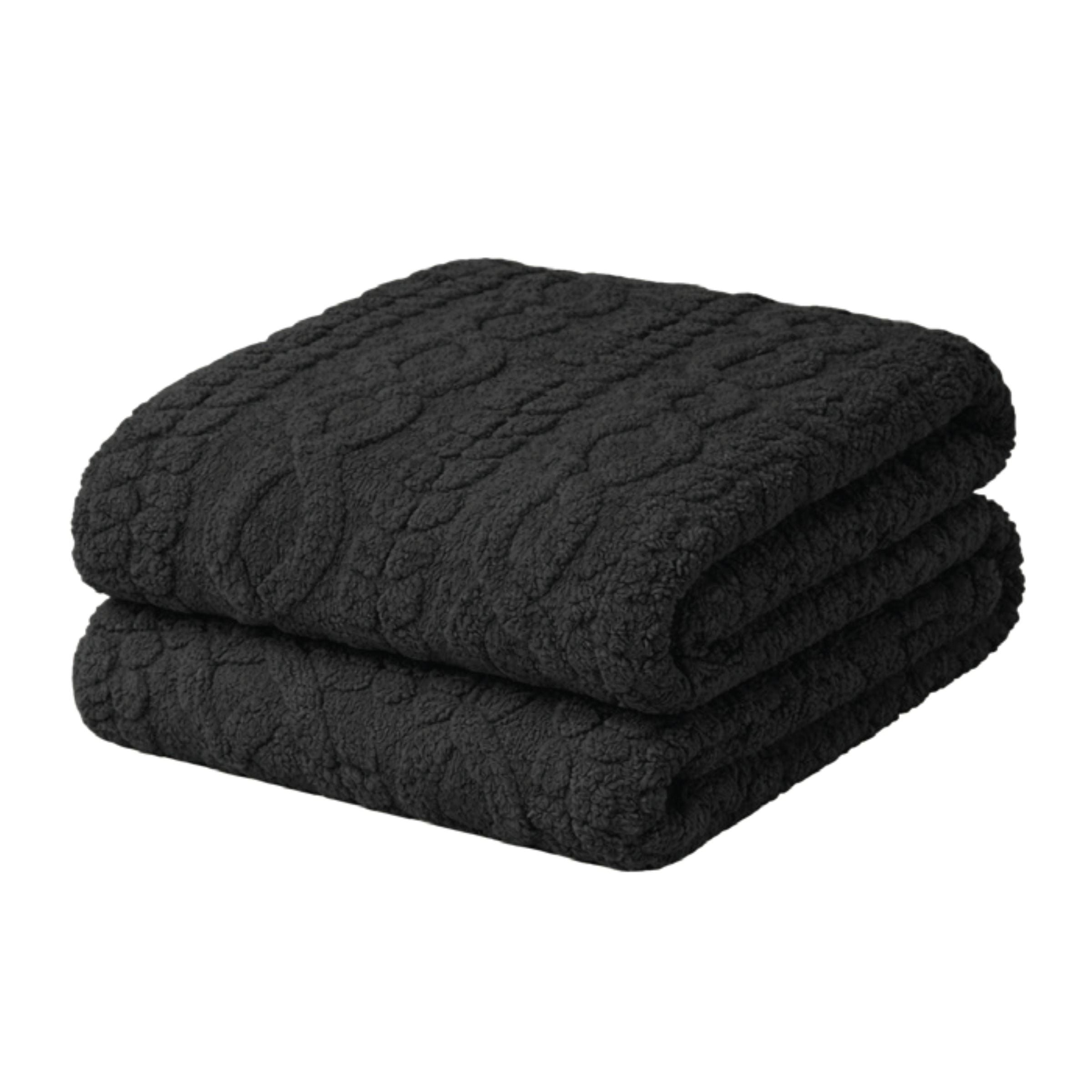 Folded black textured blanket on a white background.