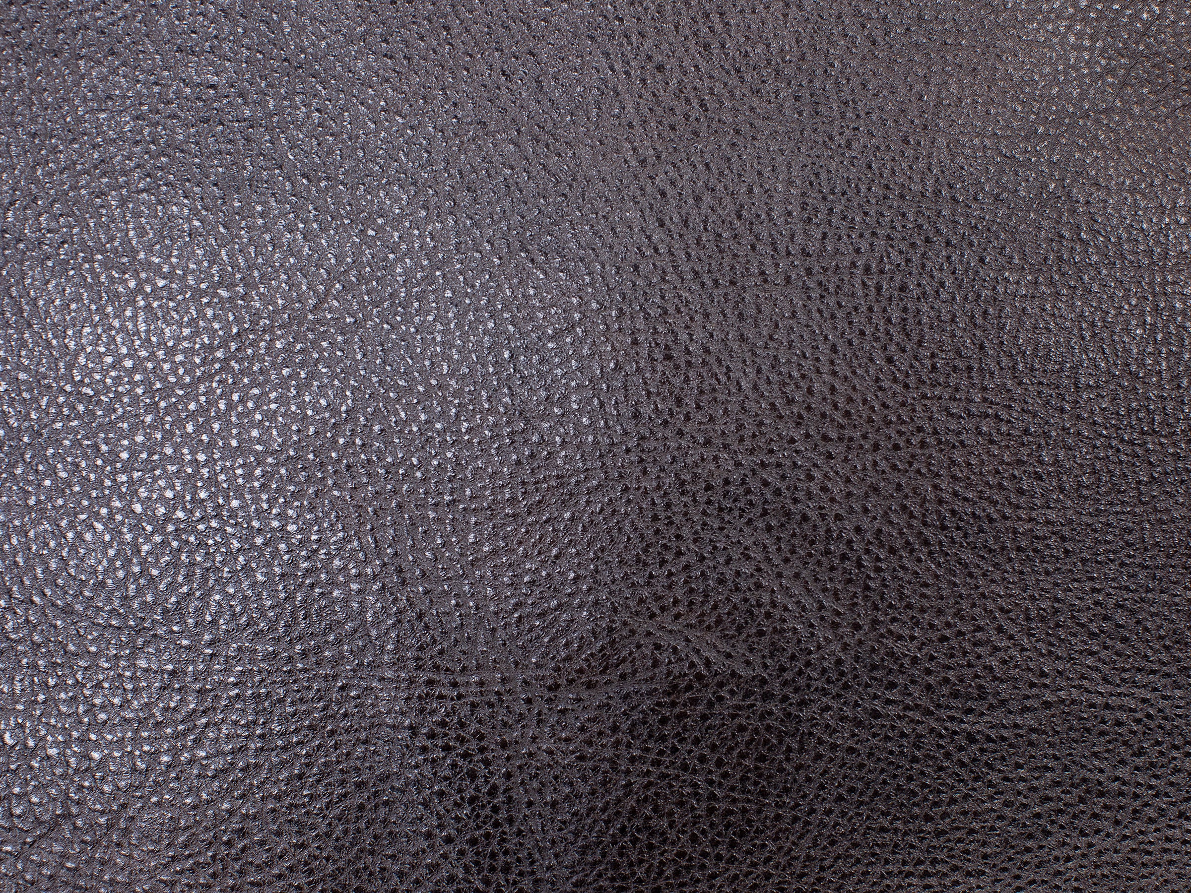 Close-up of dark textured leather material surface.