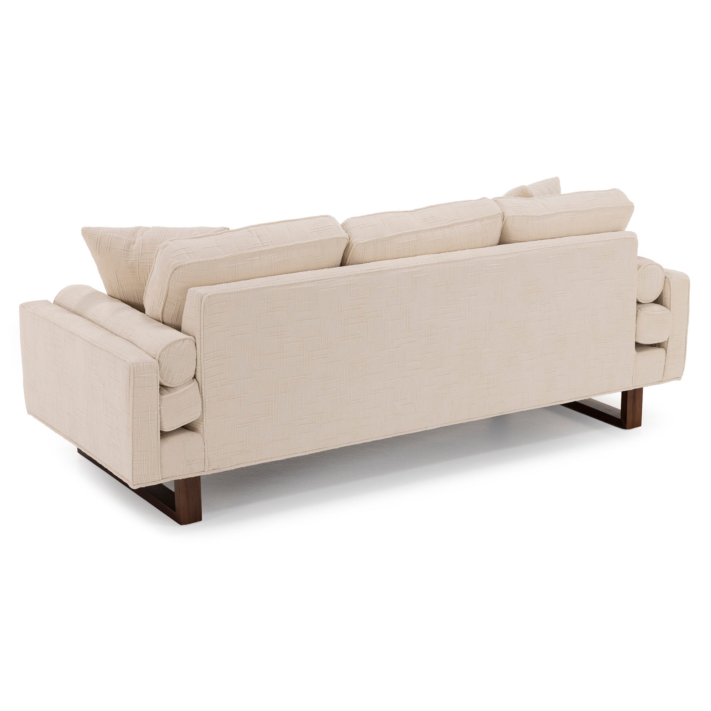 Back view of a modern beige fabric sofa with wooden legs and loose back cushions.