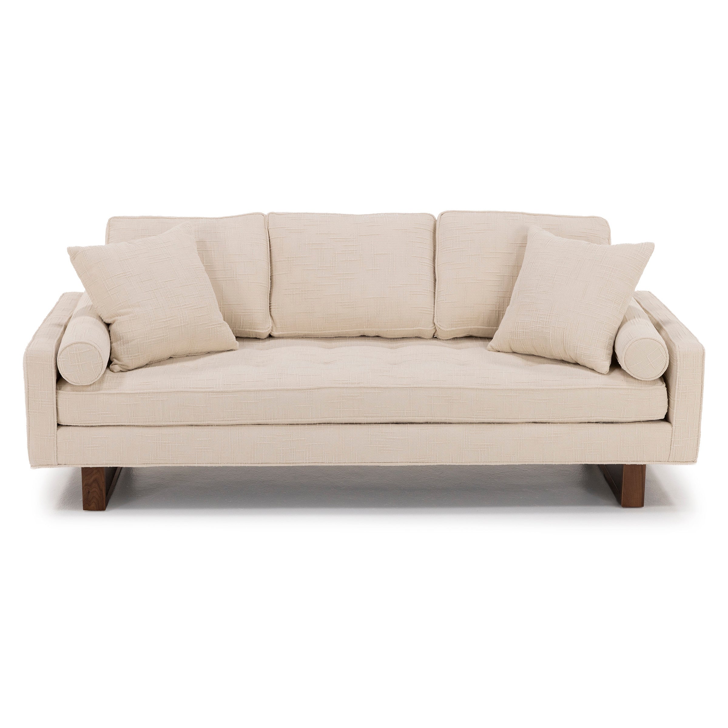 Modern beige sofa with three cushions and two accent pillows.