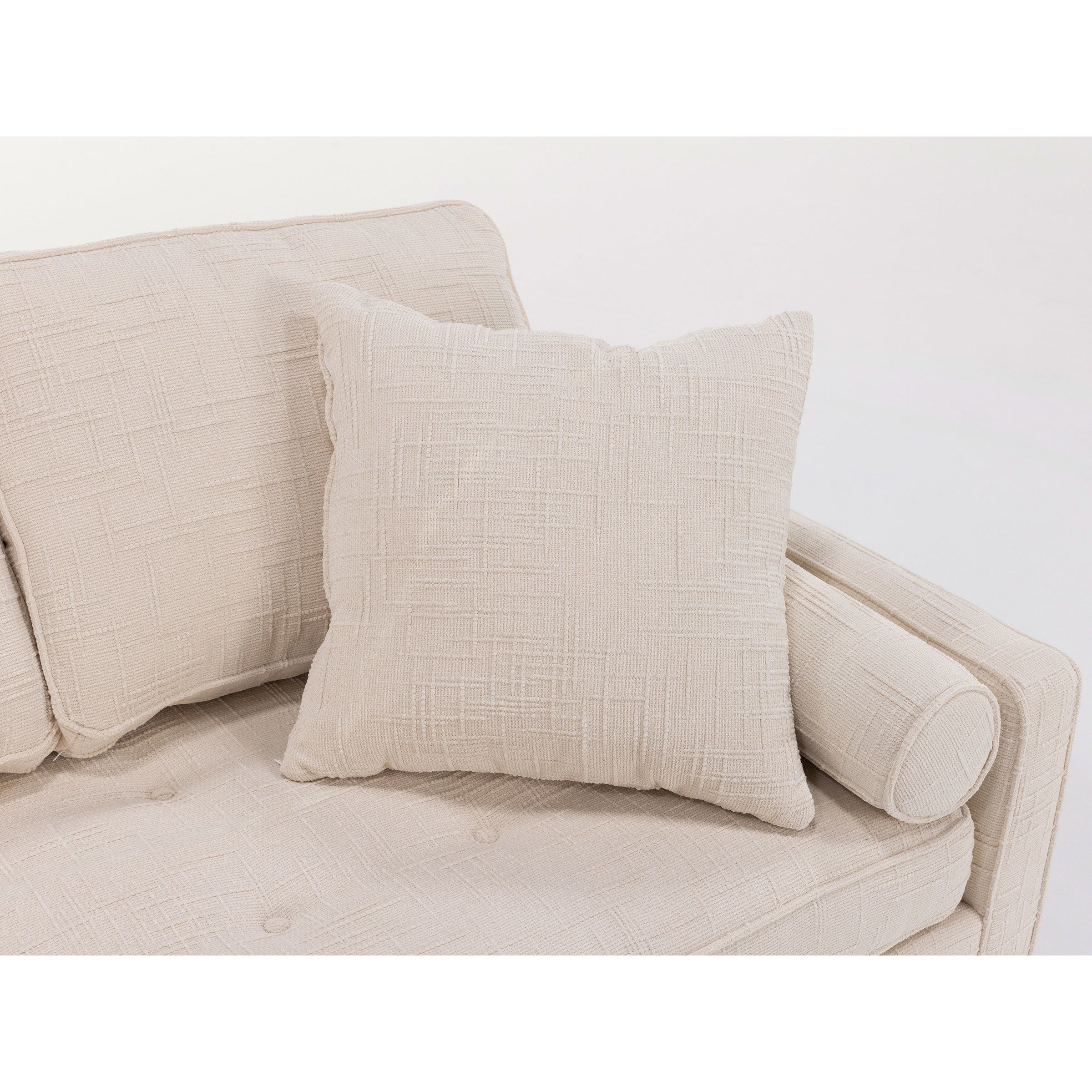 Beige textured throw pillow on matching upholstered sofa arm.