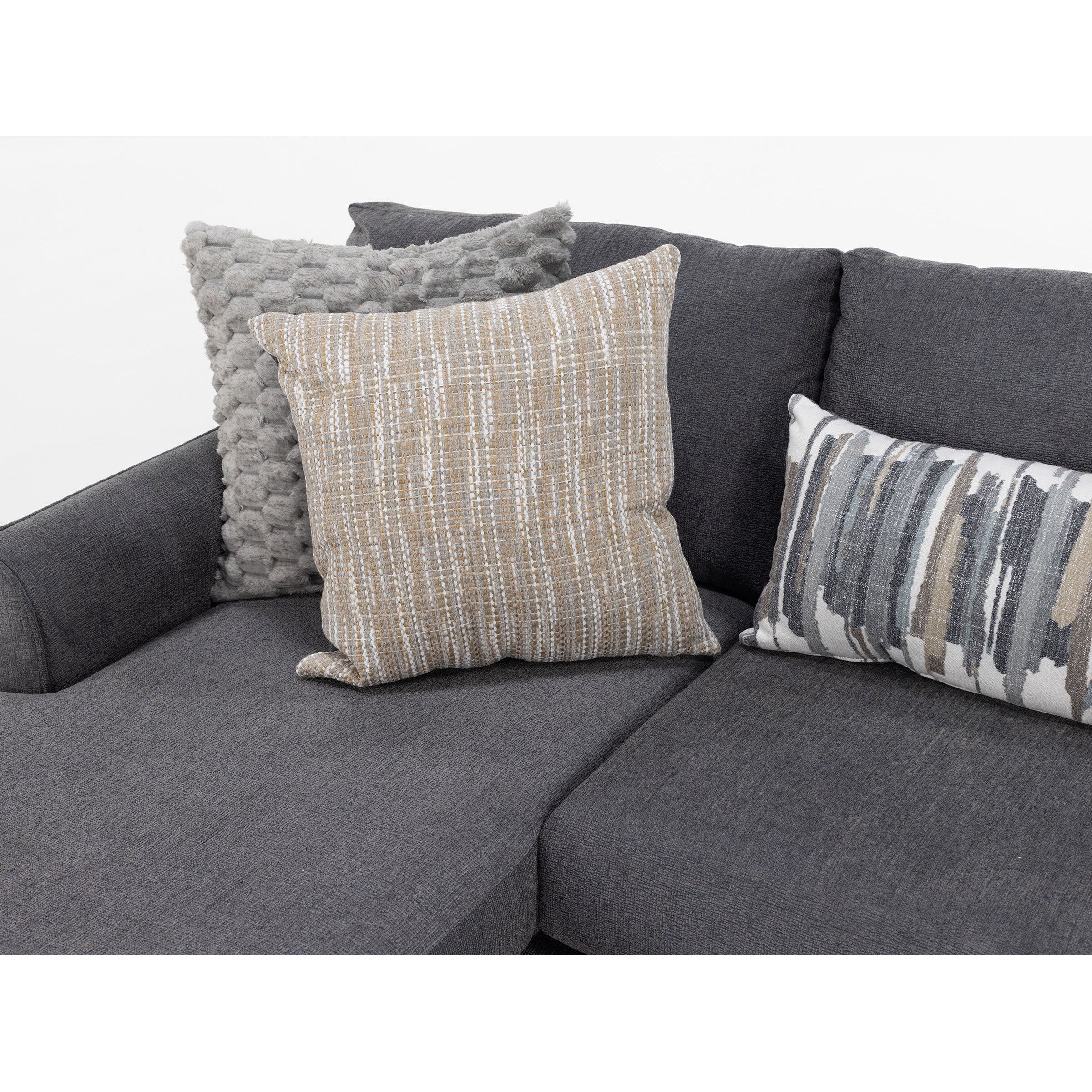 Close-up of a dark gray sofa with three decorative pillows in neutral tones.