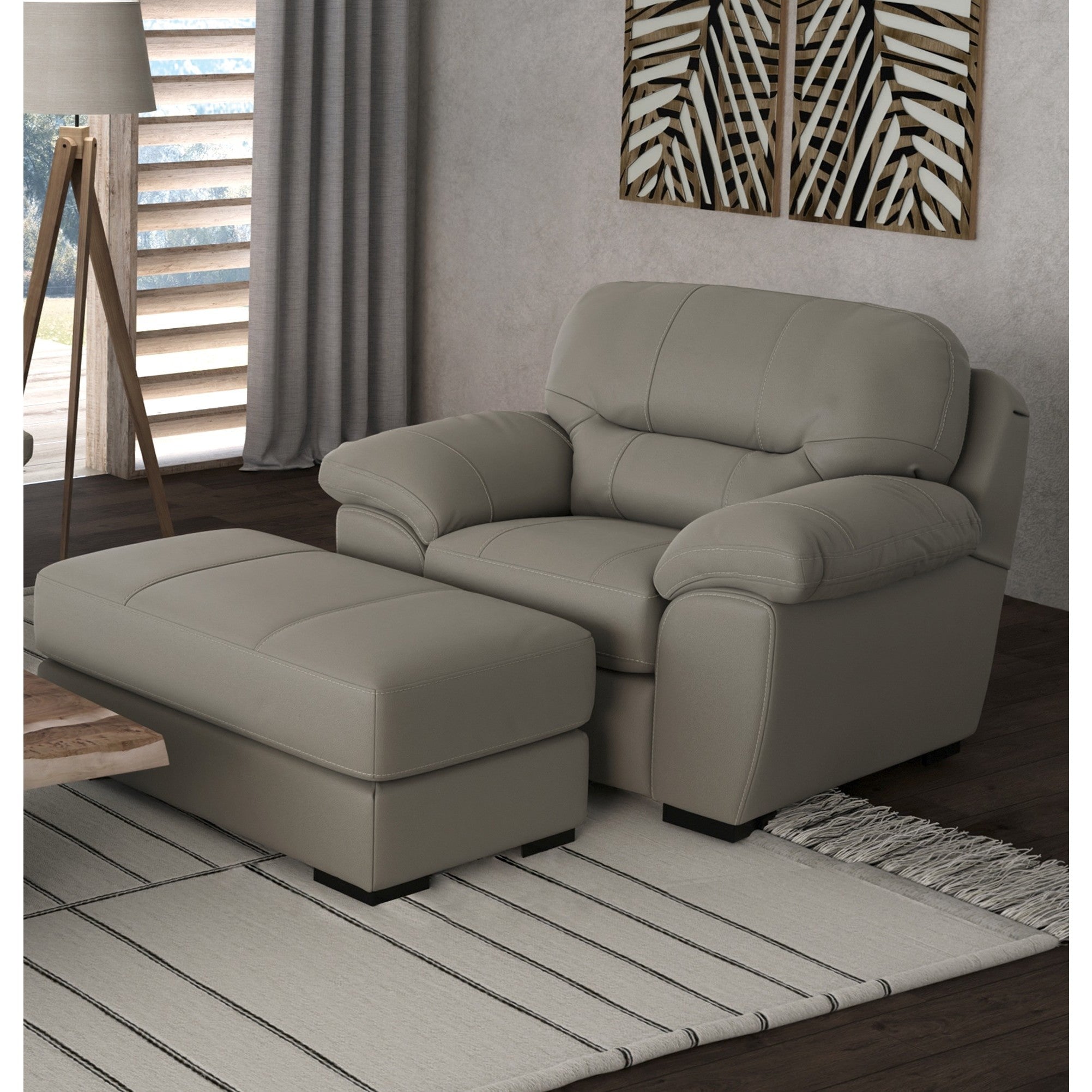Taupe armchair and ottoman in modern living room with rug and wall art.