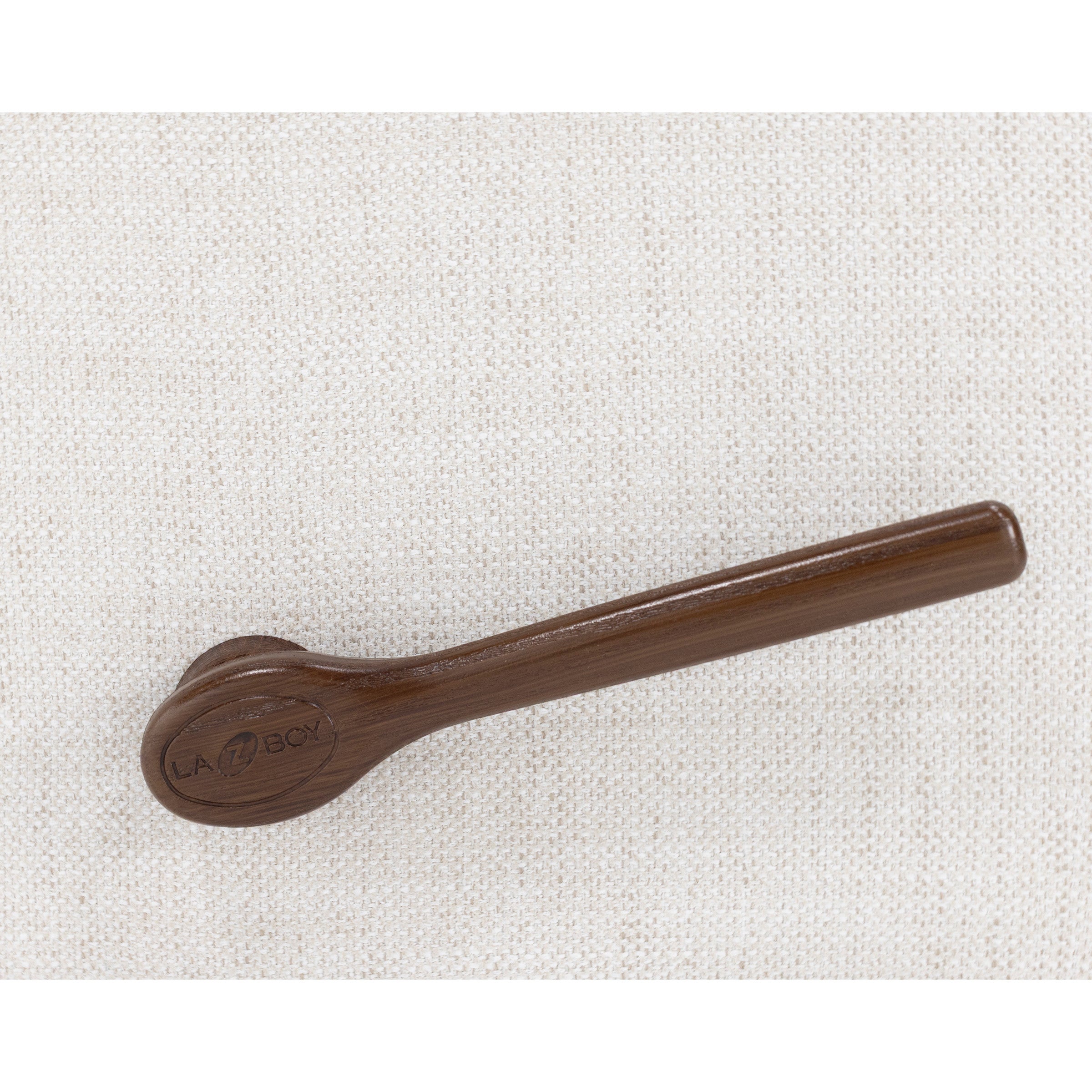 Wooden recliner handle on a light fabric background.