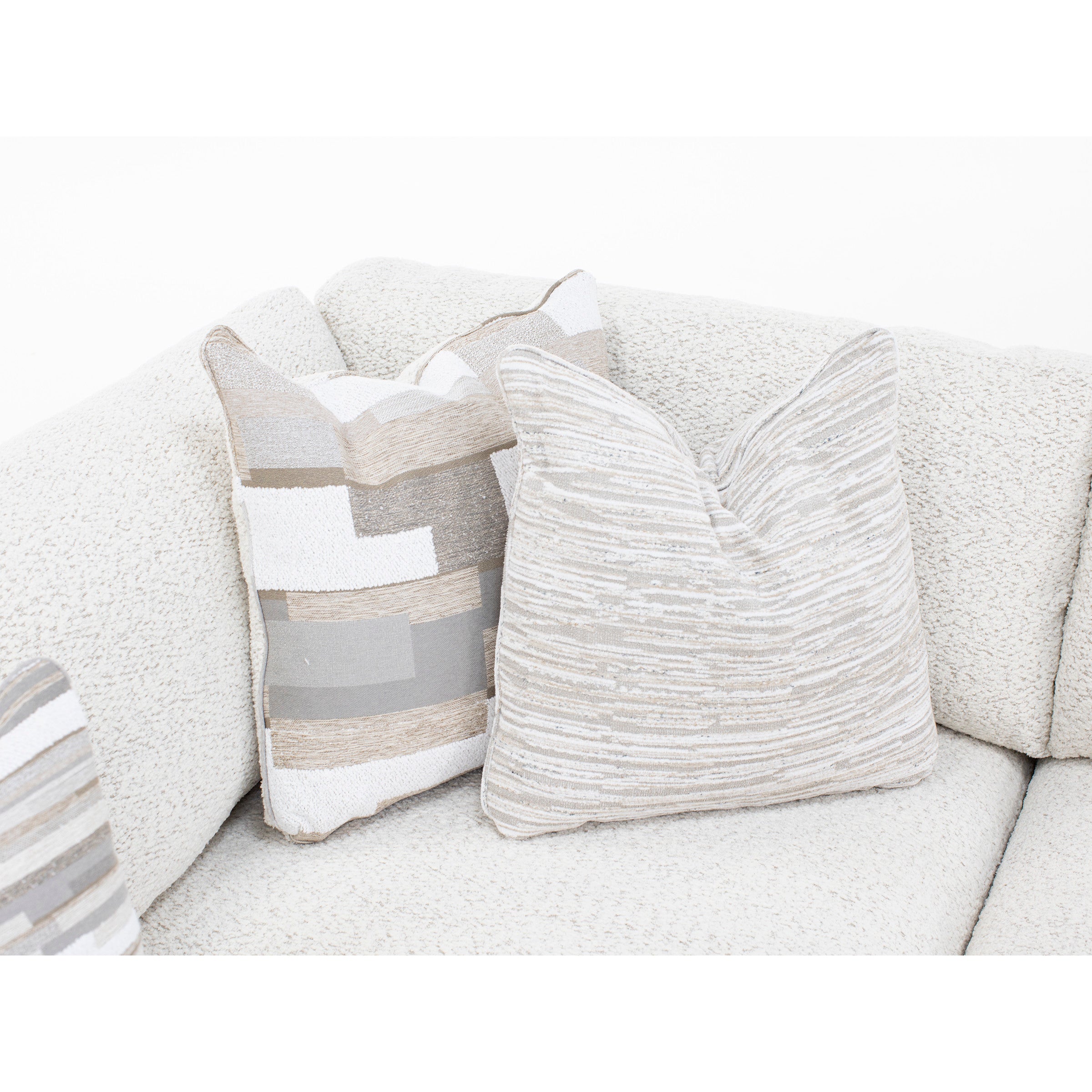 Neutral throw pillows on a textured cream sofa.