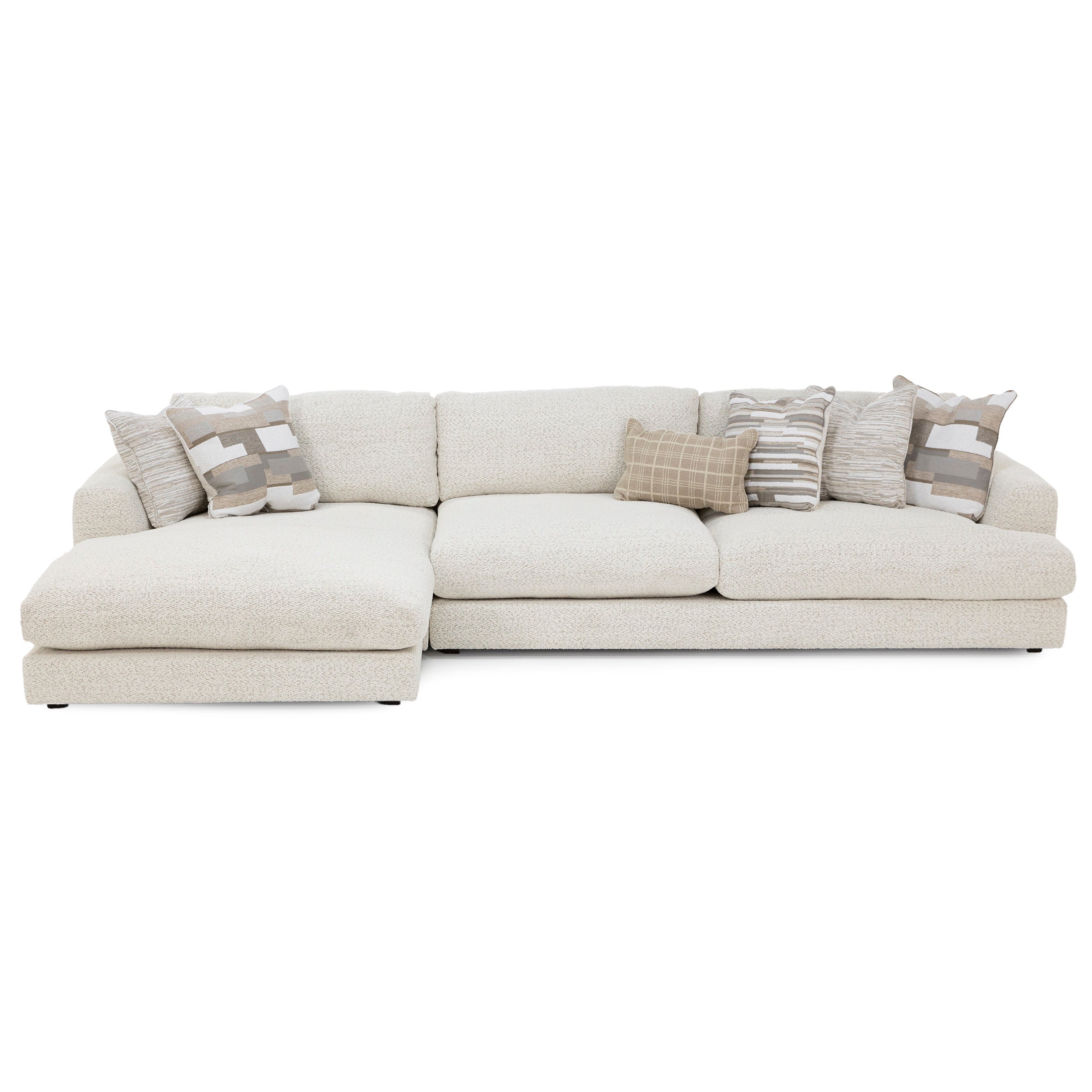 Beige sectional sofa with chaise lounge and five patterned throw pillows.