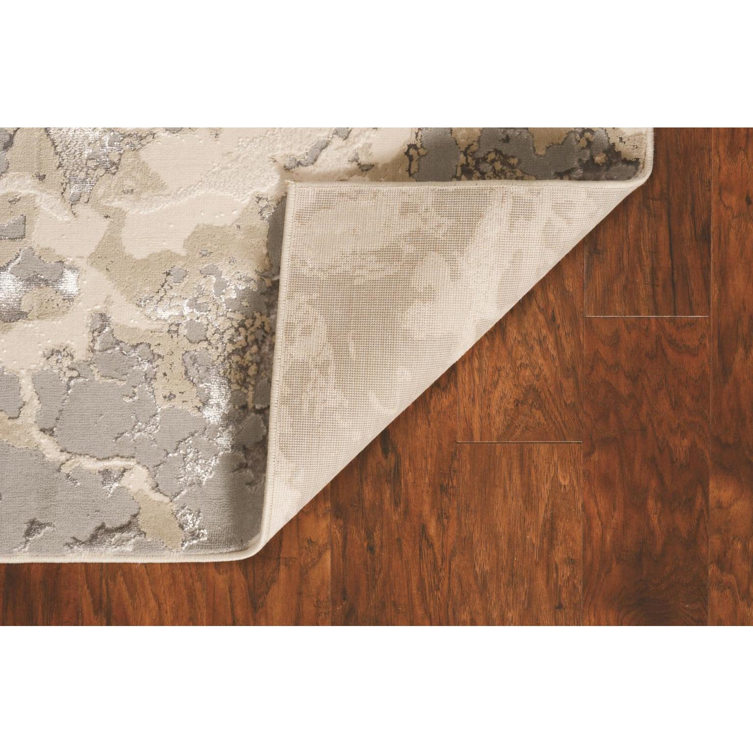 Corner of a patterned rug lifted to show hardwood floor underneath.