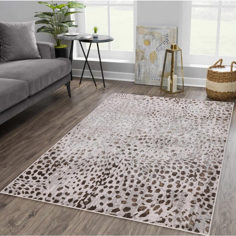 Modern living room with a light brown spotted area rug on wood flooring.
