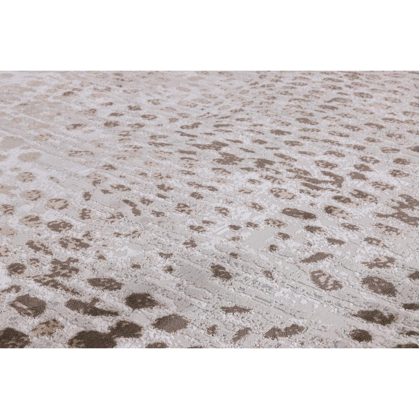 Close-up of a beige and taupe textured rug with an abstract spotted pattern.
