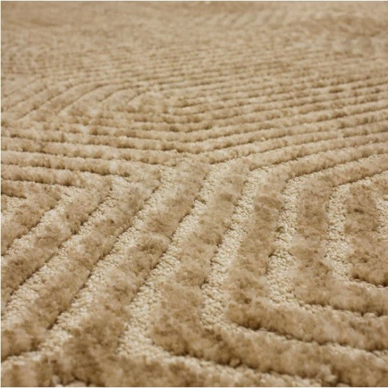 Close-up of a beige textured rug with a raised geometric pattern.