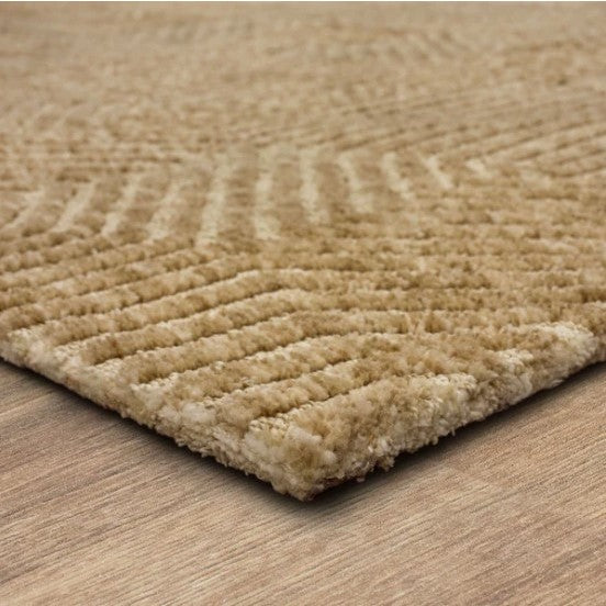 Close-up of a textured beige area rug corner on a wood floor.