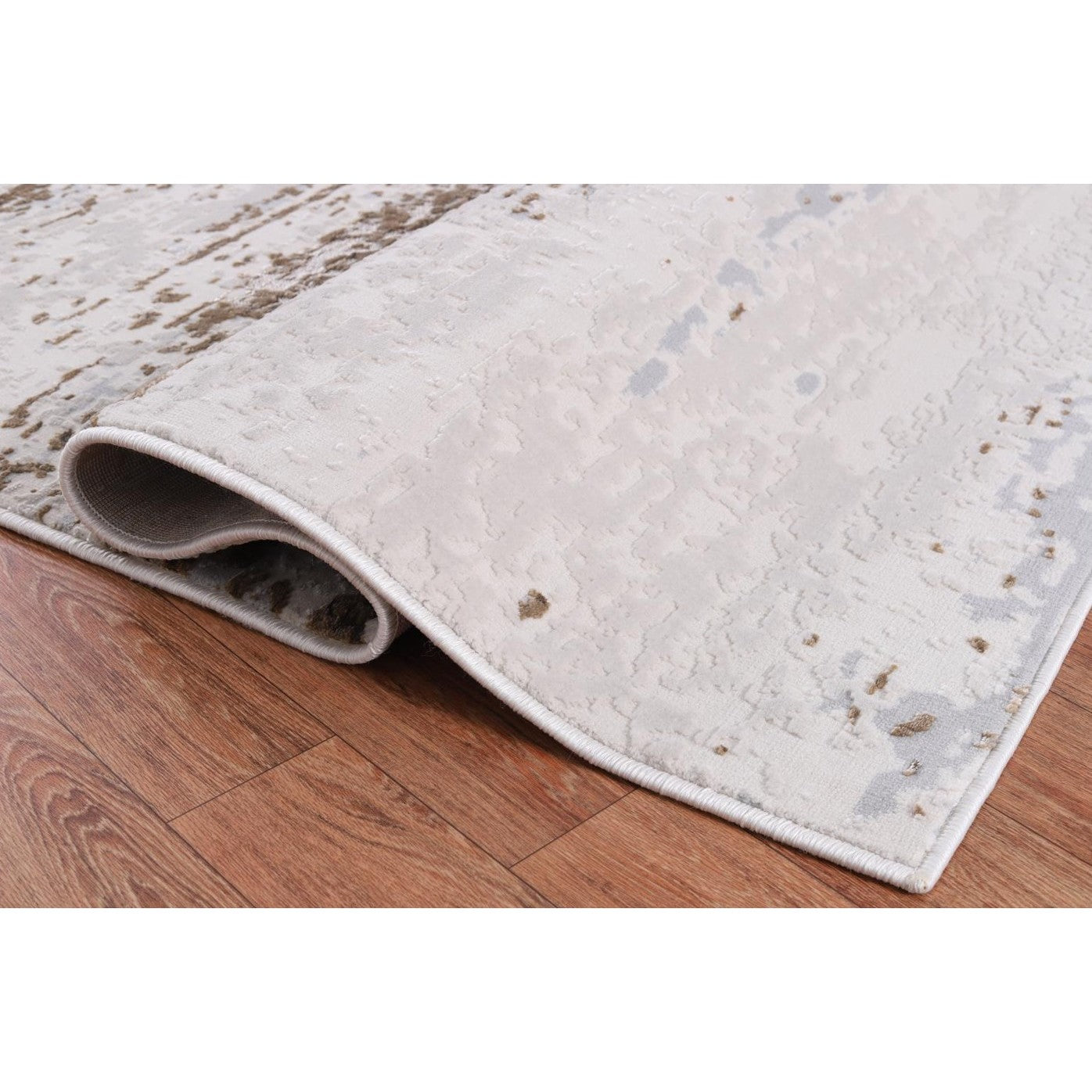 Close-up of a light colored area rug with subtle abstract pattern on wood floor.