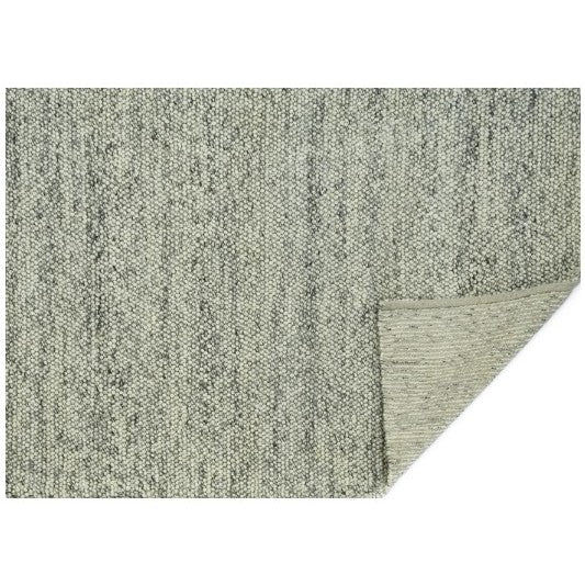 Close-up of corner-folded, textured gray rug on white background.