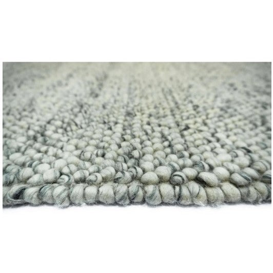 Close-up of a textured light gray woven rug.