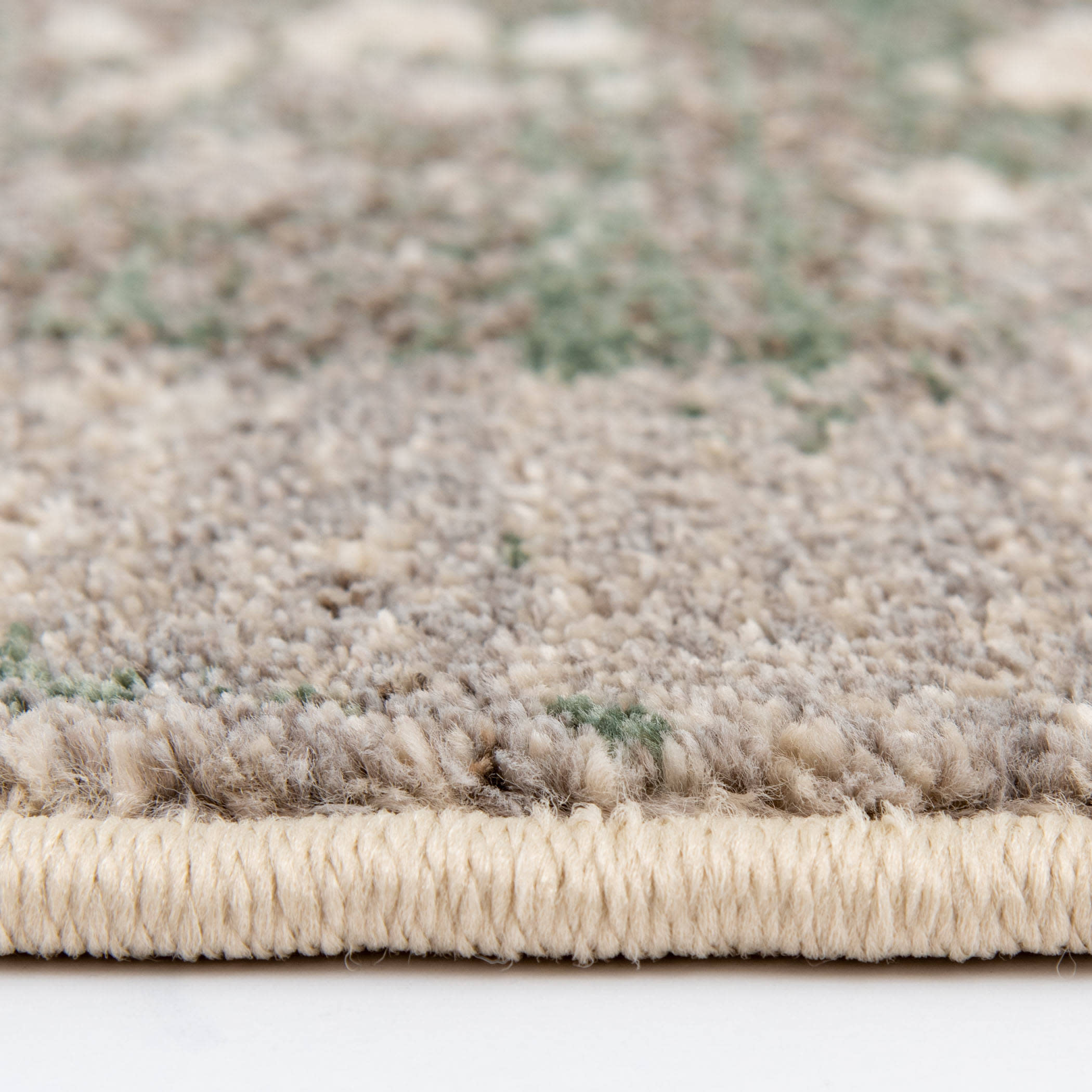 Close-up view of a textured area rug with a woven edge.