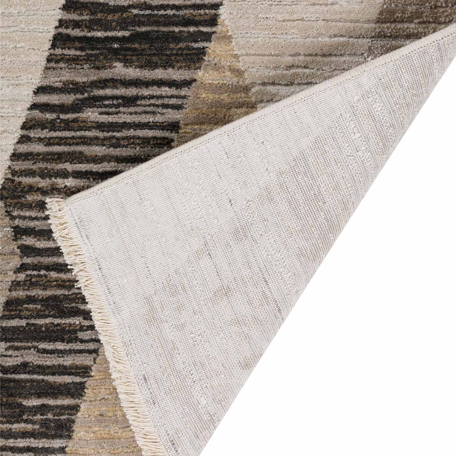 Corner of a modern rug with geometric pattern and fringed edge shown.