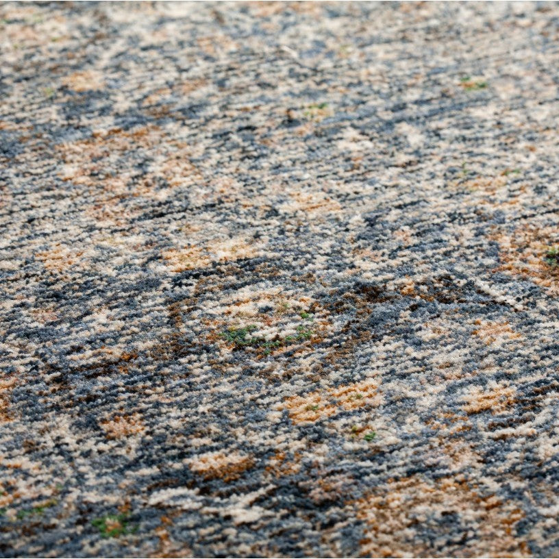 Close-up of a textured, multi-colored area rug with a blue, beige, and gray abstract pattern.