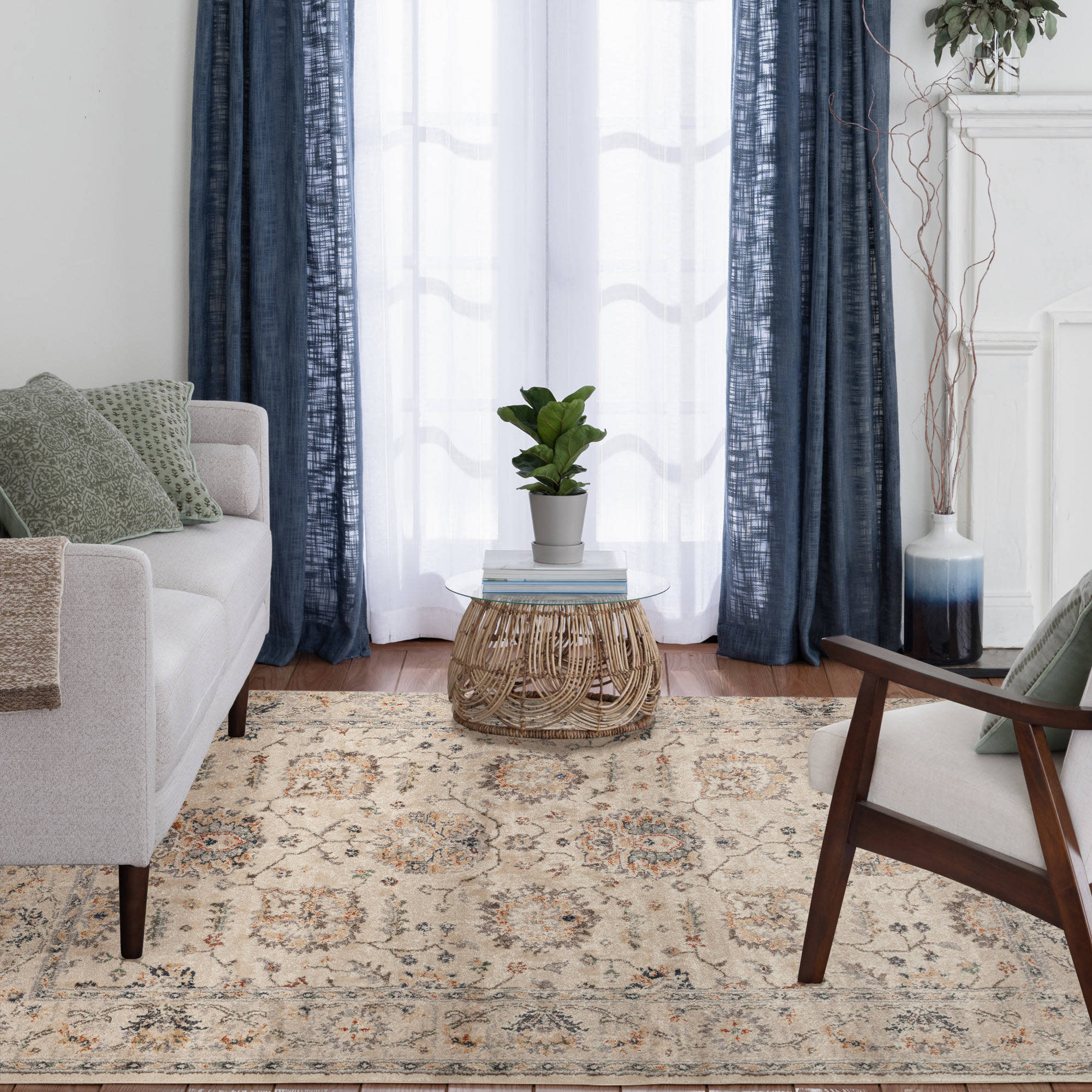 Living room with a patterned area rug, neutral furniture, and a small round coffee table.