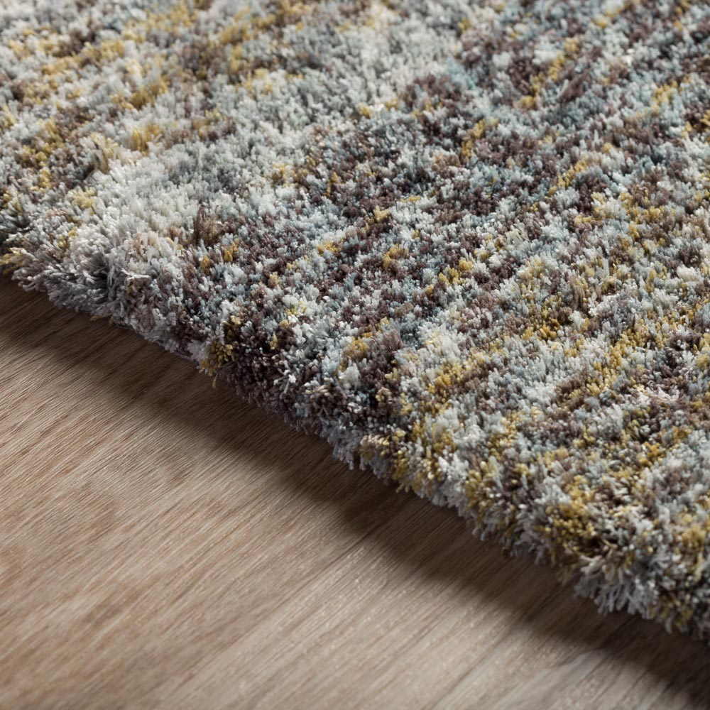 Close-up of a multicolor plush area rug corner on wood floor.
