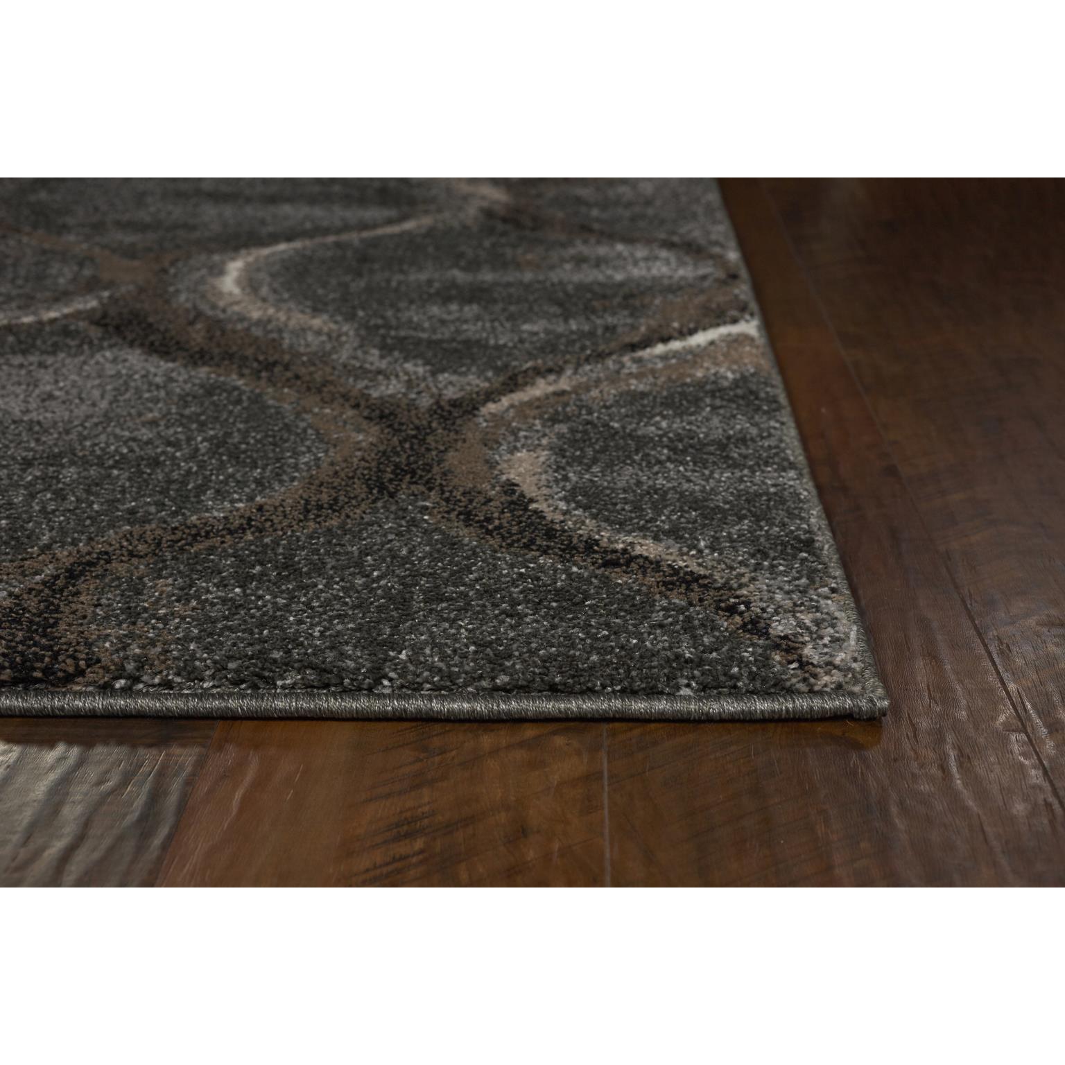Close-up of a modern dark area rug with a wavy pattern on a wooden floor.