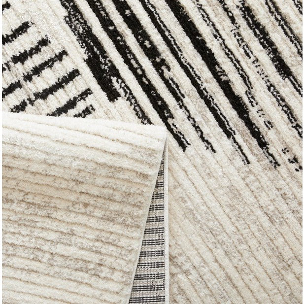 Close-up of a cream and black patterned rug corner showing texture and design.