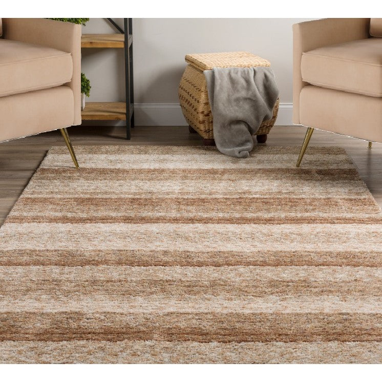 Beige and brown striped area rug in a modern living room with neutral chairs and wood floor.