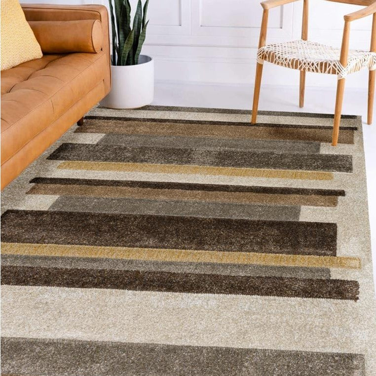 Modern area rug with geometric stripes in neutral and brown tones under a sofa and chair.